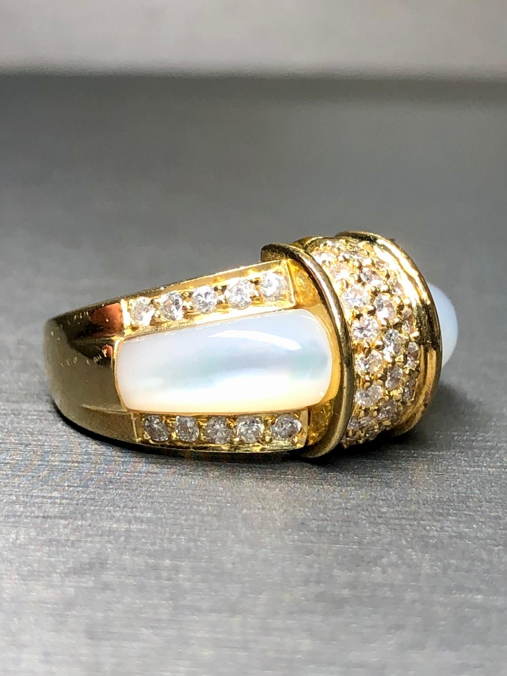 
A contemporary cocktail crafted in 18K yellow gold and inlaid with natural white mother of pearl carvings surrounded by .66cttw (stamped) in H-I color Vs2-Si1 clarity round diamonds.


Dimensions/Weight:

Ring measures .45” top to bottom and weighs