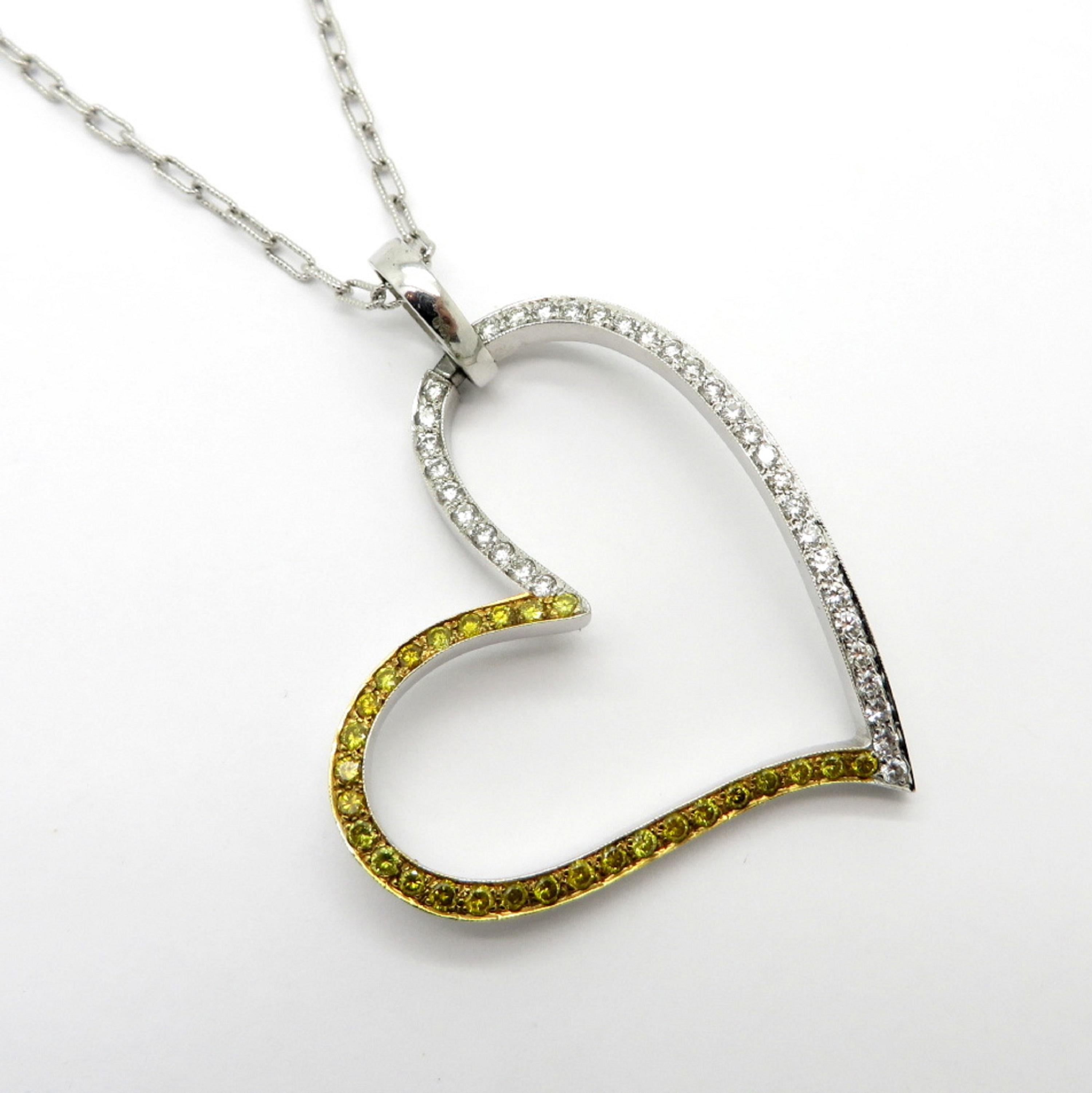 Estate 18K white gold diamond and fancy yellow round diamond large heart pendant necklace. Showcasing 35 white round brilliant cut diamonds weighing approximately 0.50 carats. Accented with 20 fancy radiated yellow round brilliant cut diamonds