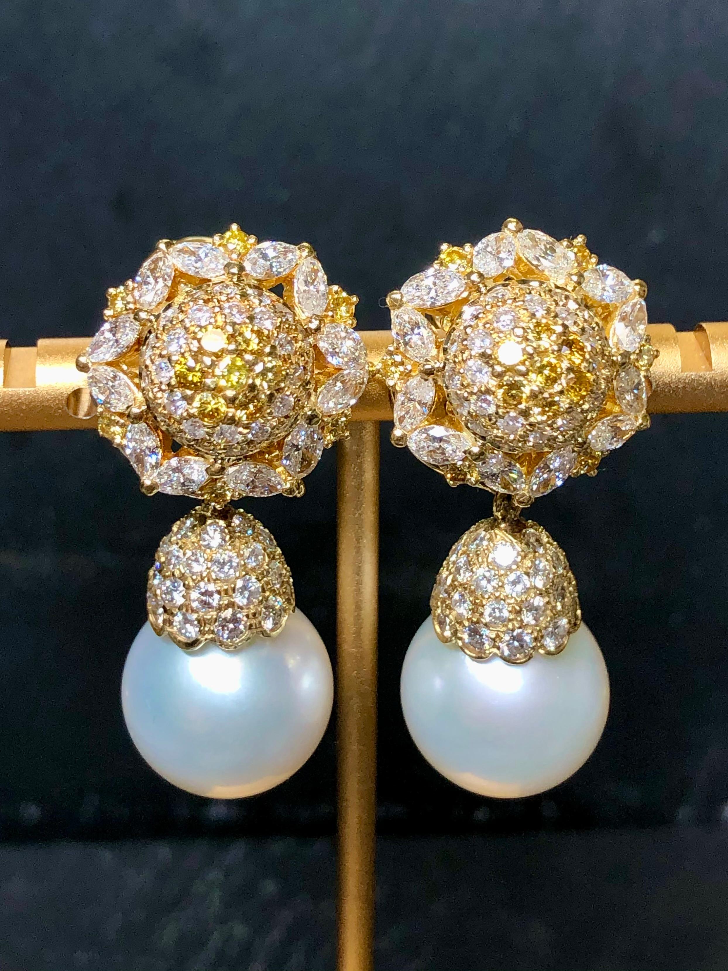 
A fabulous pair of day/night earrings set with approximately 5.36cttw in marquise and round diamonds averaging G-I in color and Vs1-Si1 in clarity as well as .82cttw in fancy yellow round diamonds. Suspended from each top are 14.50mm South Sea
