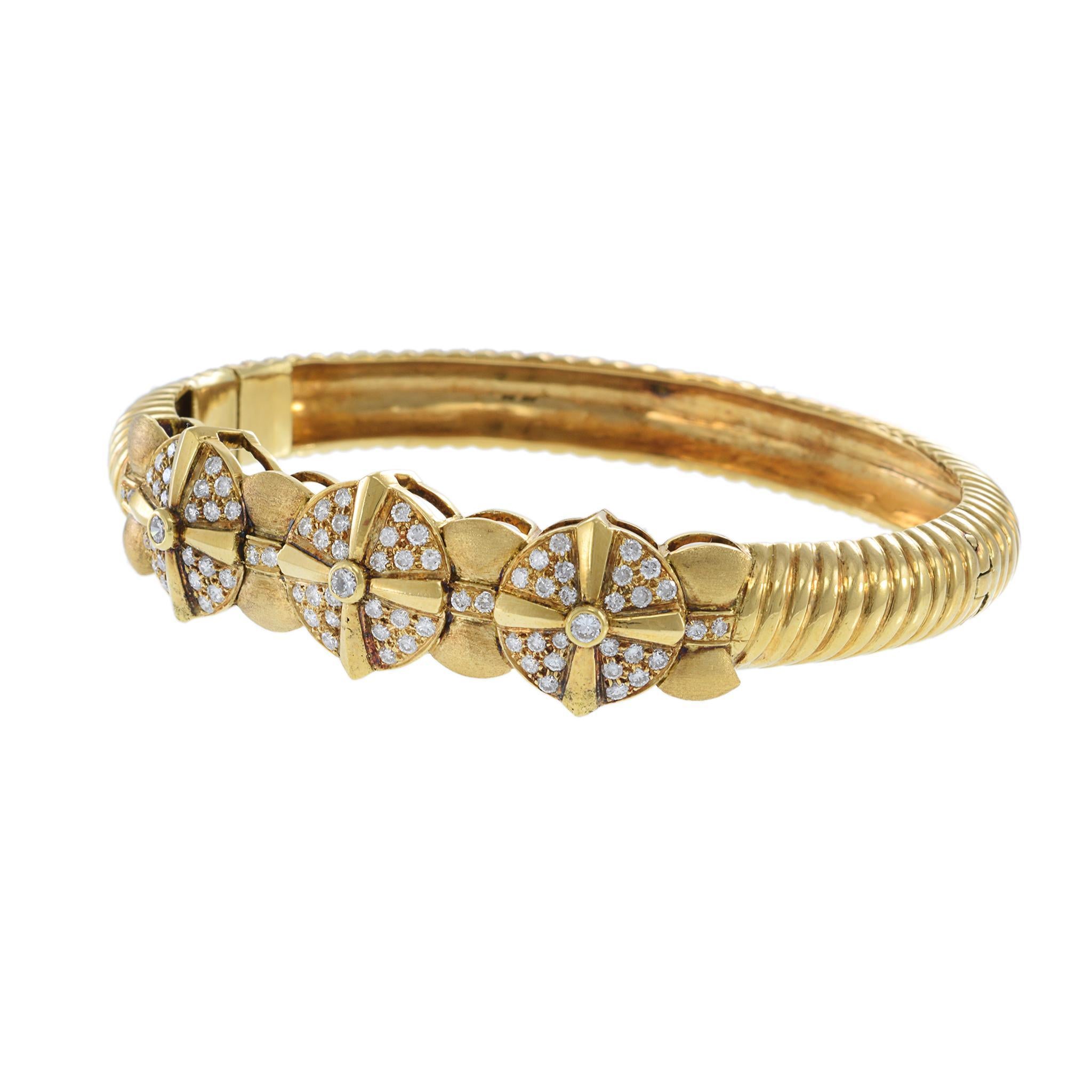 Este brazalete vintage de oro amarillo de 18 quilates presenta un diseño escultural de tres secciones adornado con diamantes redondos talla brillante que suman aproximadamente 1,00 quilate. Cada sección está acentuada con piedras de calidad G-VS