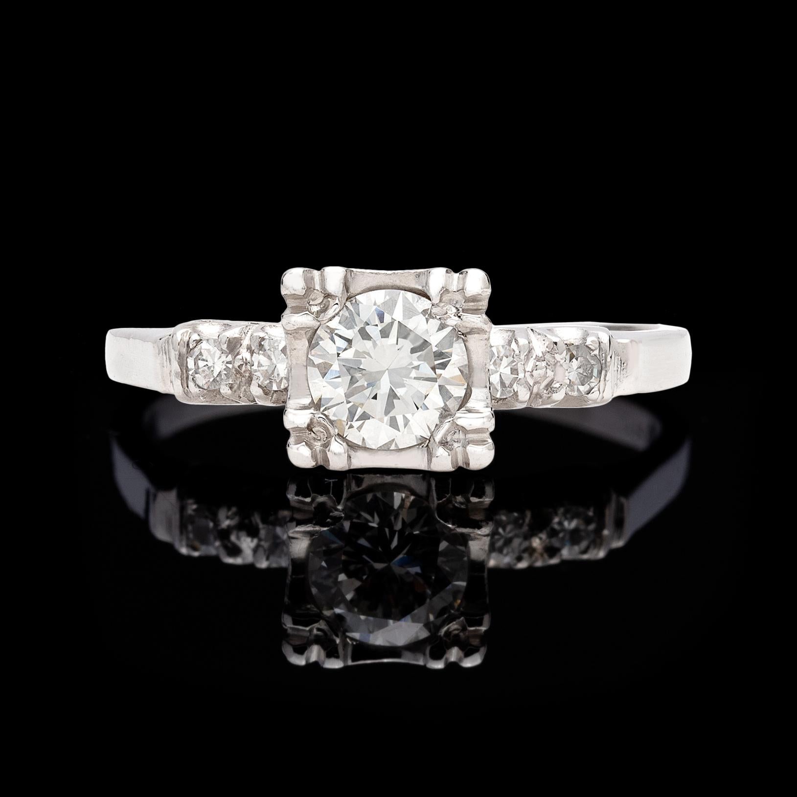 Charming 1950's platinum engagement ring centering a sparkling round brilliant-cut diamonds weighing approximately 0.65 carat, G-H color and VS clarity, set in  square design prongs, with a band accented by 4 single-cut diamonds. Estimated total