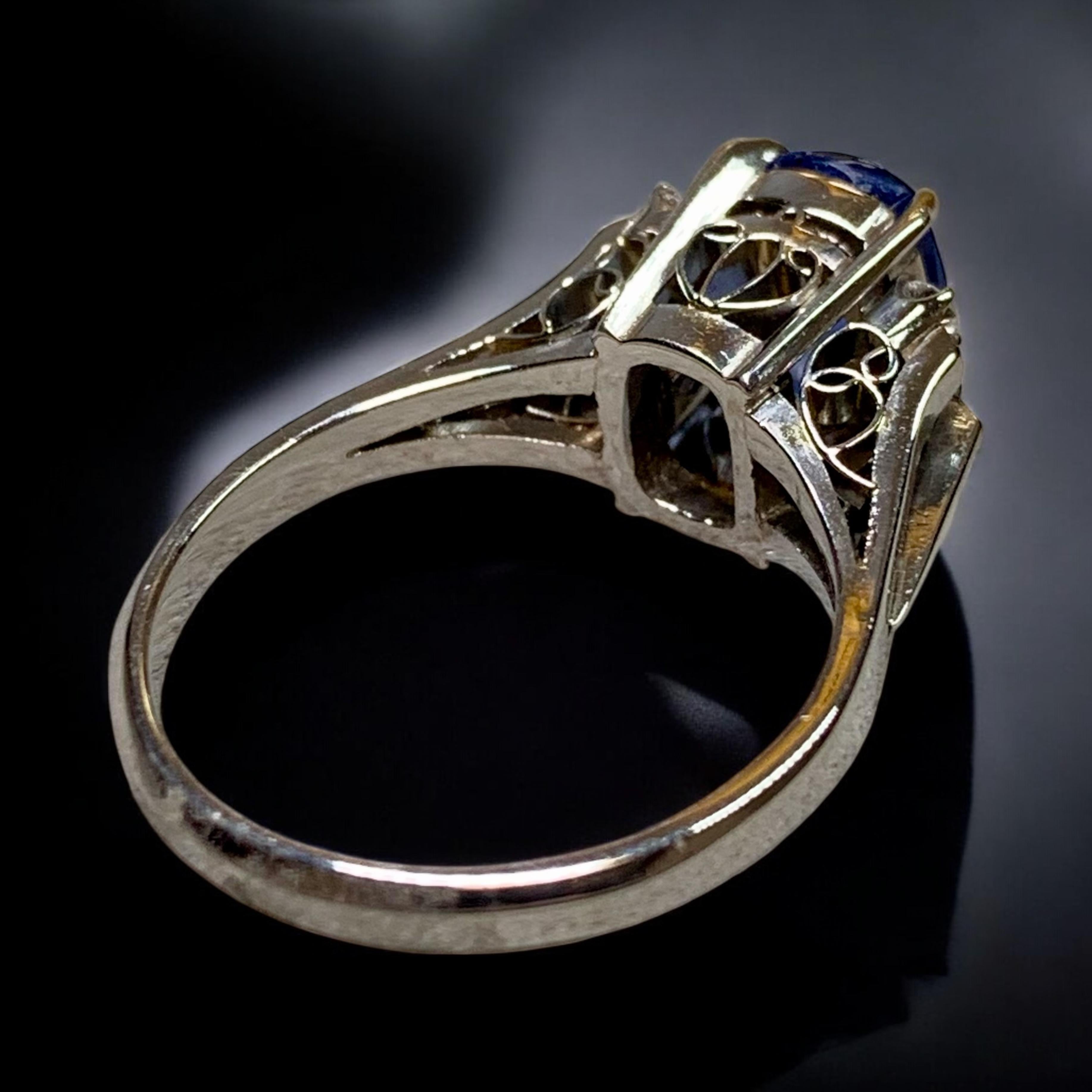 Ein süßer und eleganter Vintage-Saphirring aus Platin, zierlich in der Größe und voller Charme. Im Mittelpunkt steht ein 1,70 Karat schwerer, länglicher Saphir im Kissenschliff mit einem satten königsblauen Farbton. Der von GIA als natürlich und