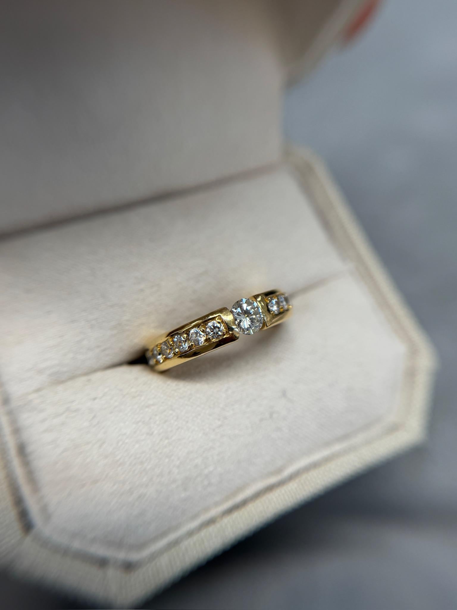 Sleek and sophisticated, this estate diamond ring features a striking 0.50ct center diamond in a modern tension setting, complemented by 1.50ct of dazzling accent stones. Crafted in rich 18k yellow gold and weighing 10.30g, this piece blends
