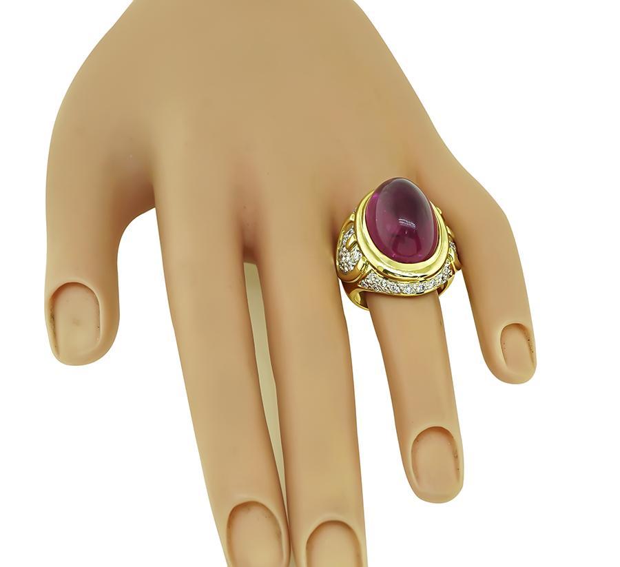 Il s'agit d'une élégante bague en or jaune et blanc 18 carats. La bague est centrée sur une tourmaline rose cabochon qui pèse environ 22,82ct. La pierre centrale est accentuée par des diamants ronds étincelants qui pèsent environ 1.50 ct. La couleur