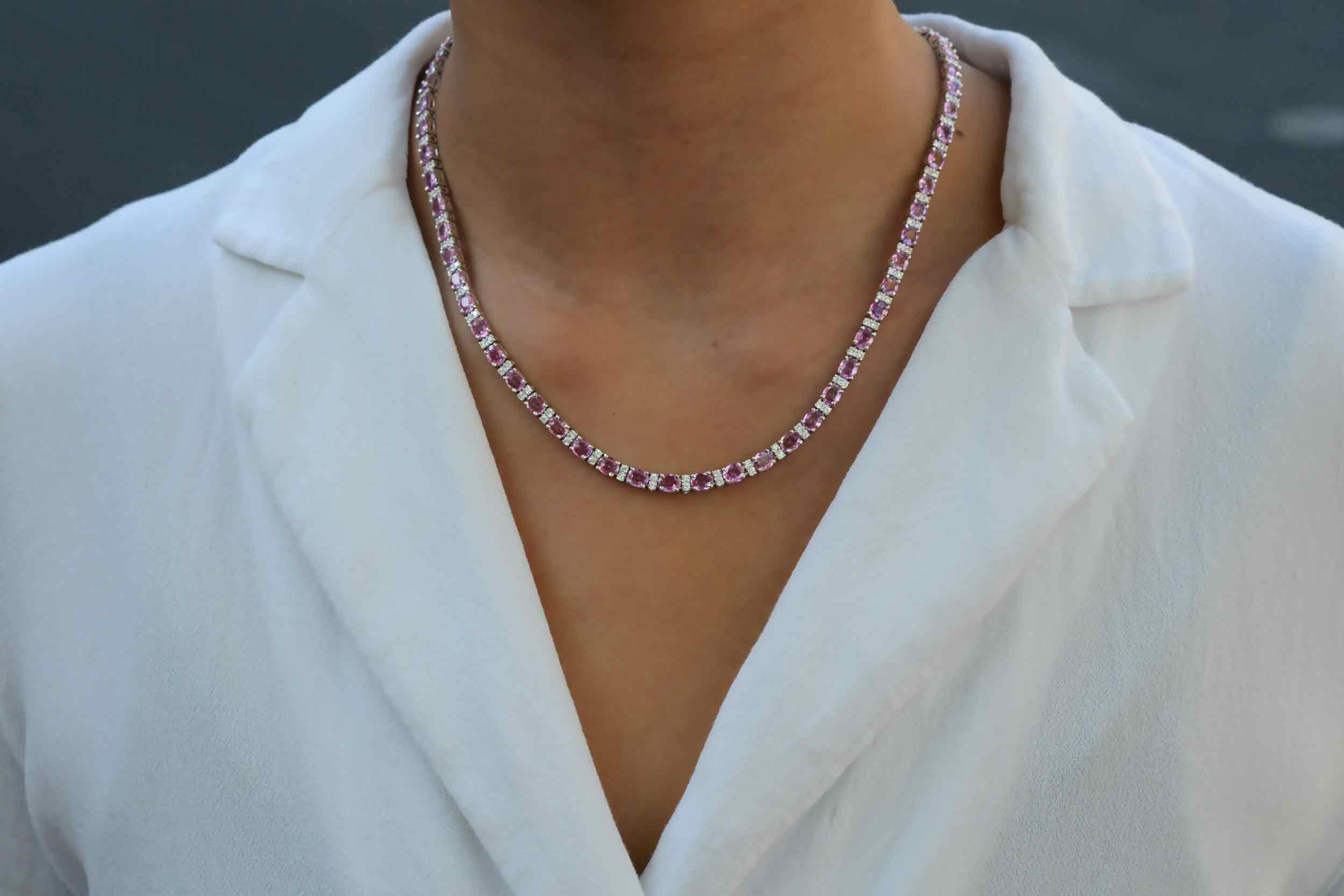 Pure elegance, this estate riviera necklace features an eternal strand of vivid-intense pink sapphires weighing a prominent 23 carats total. Integrated with stations of near colorless diamonds totaling over 1 carat, shimmering with fire and