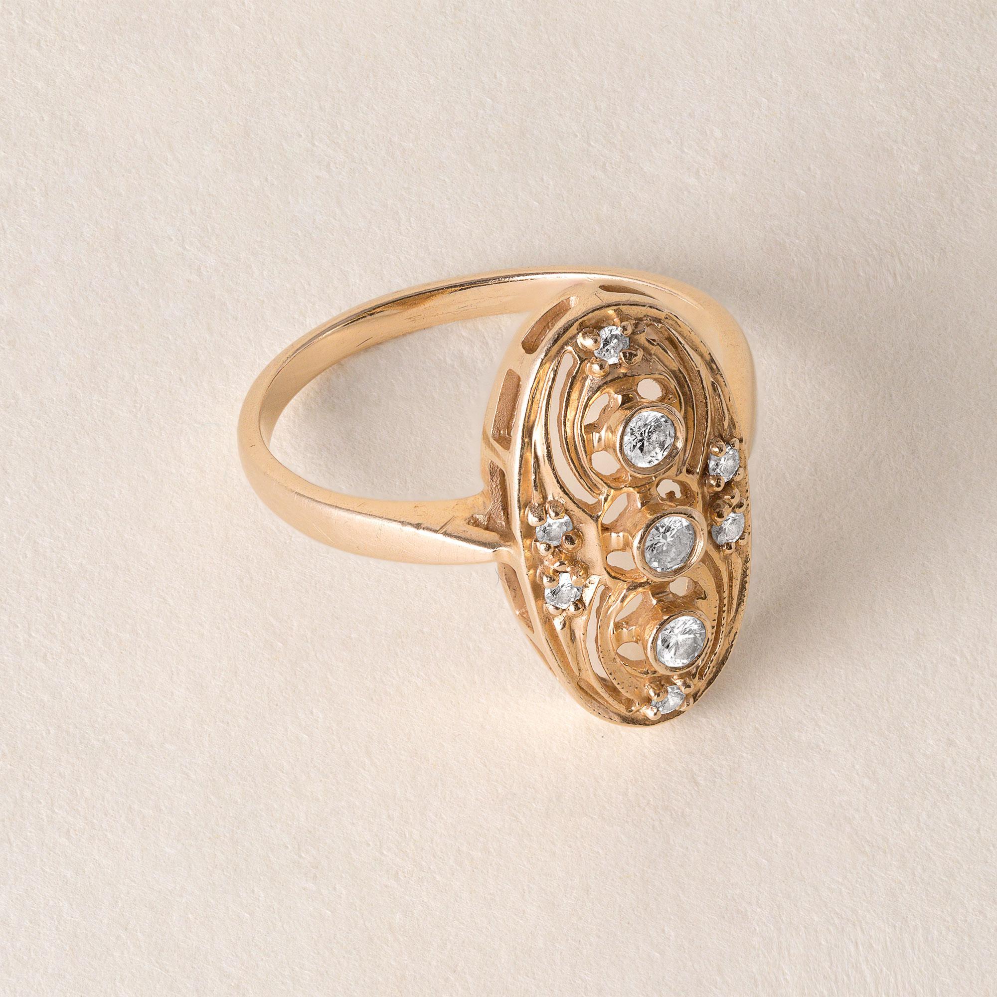 Art Deco inspired ring made in the 70's

3 diamonds bezel set vertically
6 smaller round brilliant diamond accents
0.25 carats total weight
2.9 grams
14k yellow gold, marking in the shank
Oval frame measures 17.2 x 9mm
Ring size 6.25