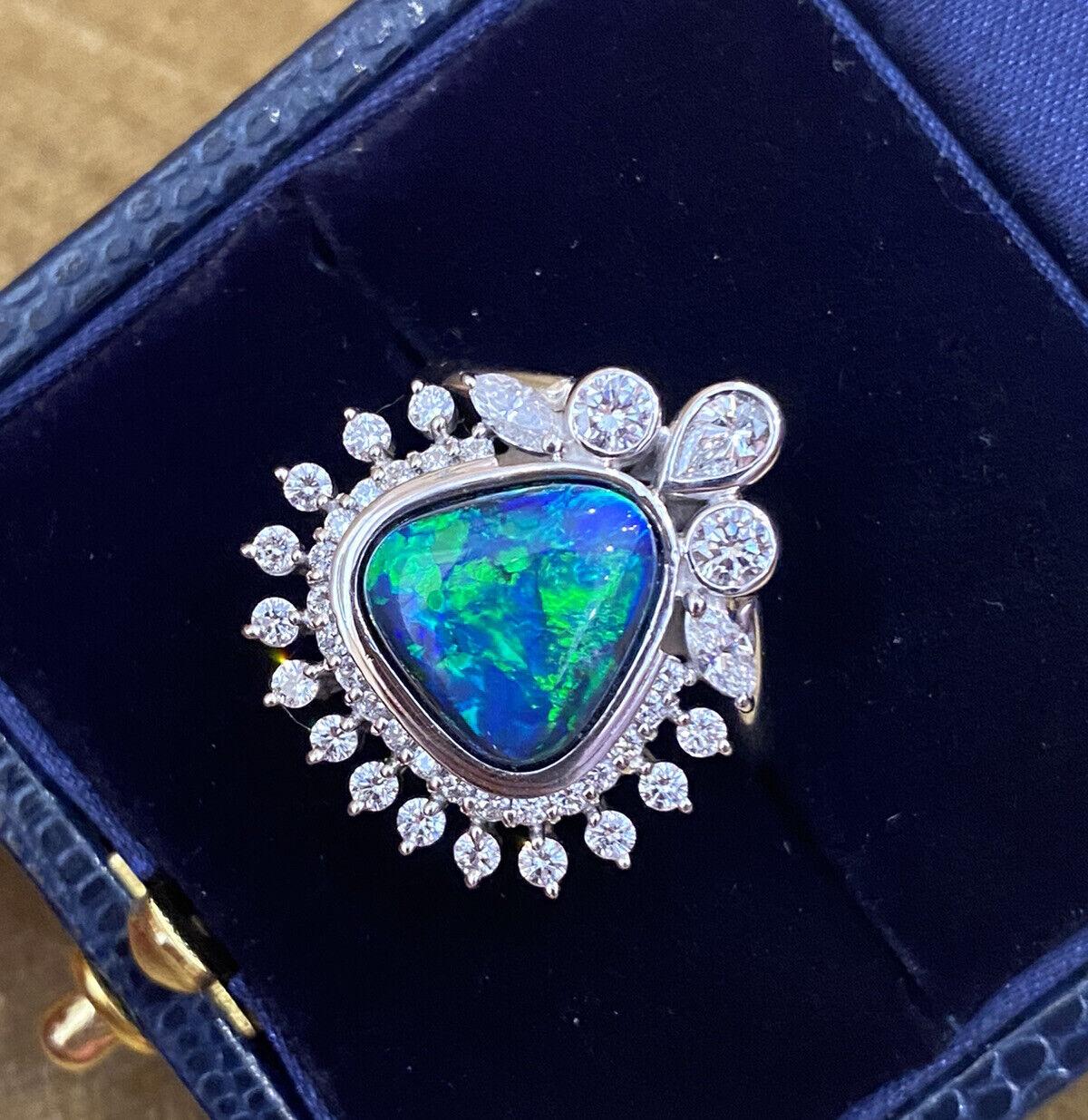 4.23 Carats Black Opal and Diamond Ring in Platinum 

Black Opal and Diamond Ring features a 4.23 carats, with beautiful blue, green, yellow coloring. 
Black Opal bezel-set in the center, surrounded by a halo of Round Diamonds and a second halo of