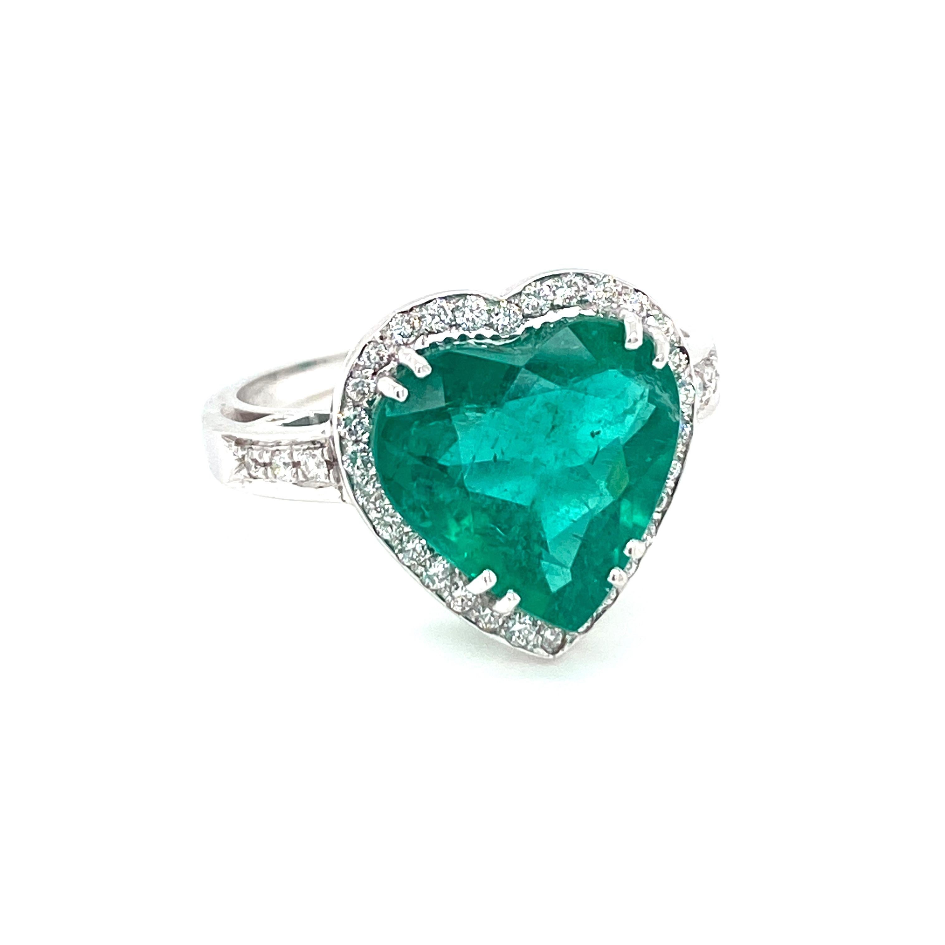Beautiful 18k white gold ring set with a vivid heart shaped Emerald weighing 5,51 carats, adorned by sparkling round brilliant cut diamonds weighing .40 ct  G color VVS1.

CONDITION: Excellent
METAL: 18k white Gold
GEM STONE: Emerald 5,51 ct -