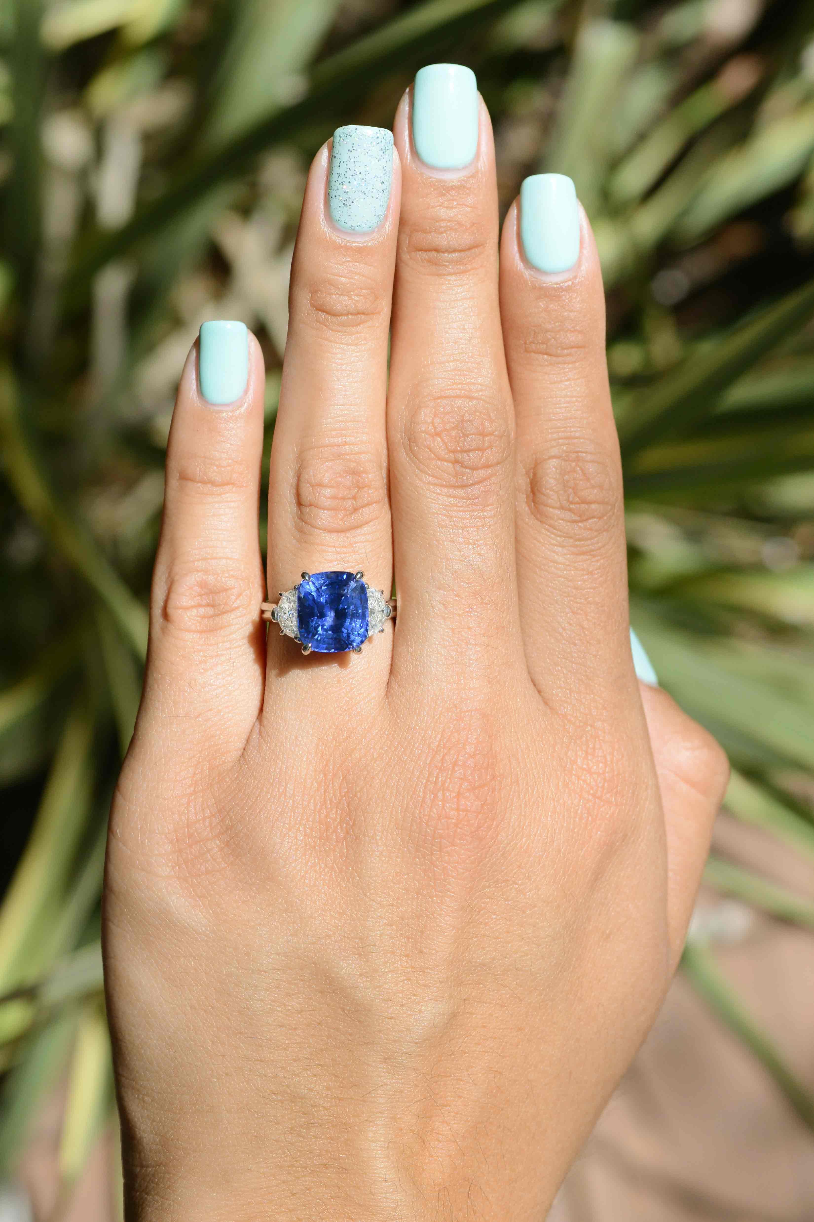 This glamorous sapphire and diamond 3 stone ring is an absolute beauty. The rich blue sapphire has an intense and vivid color that is hugged by 2 glimmering, uniquely cut half moon diamonds. Similar to Tiffany & Co. sapphire rings in styling and