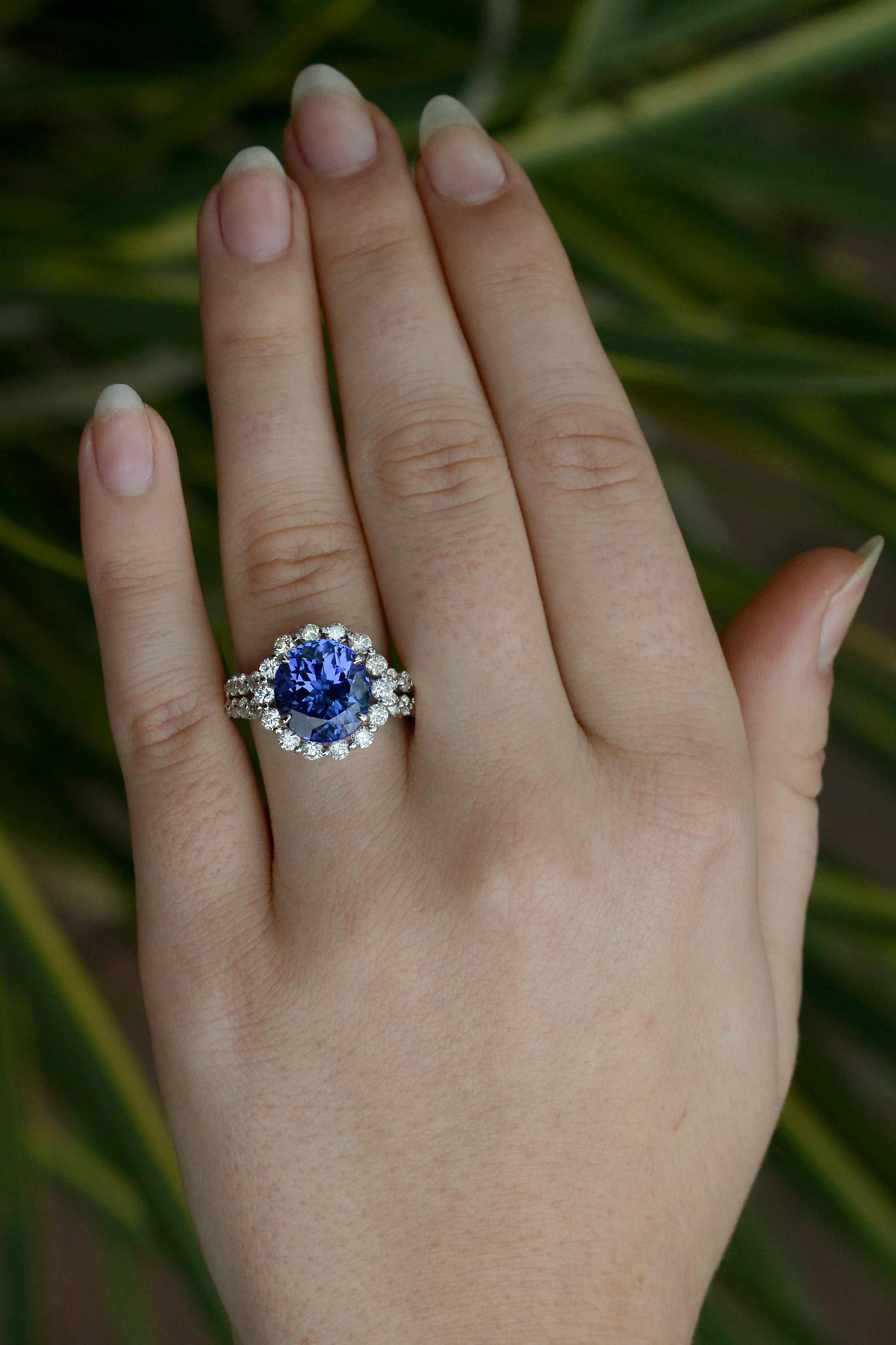 A rare round and substantial 6.15 carat tanzanite and diamond cocktail ring. The striking tanzanite flashes a deeply saturated, desirable blue tone with a scintillating velvety purple secondary color. This incredible gemstone is encircled with 1.50