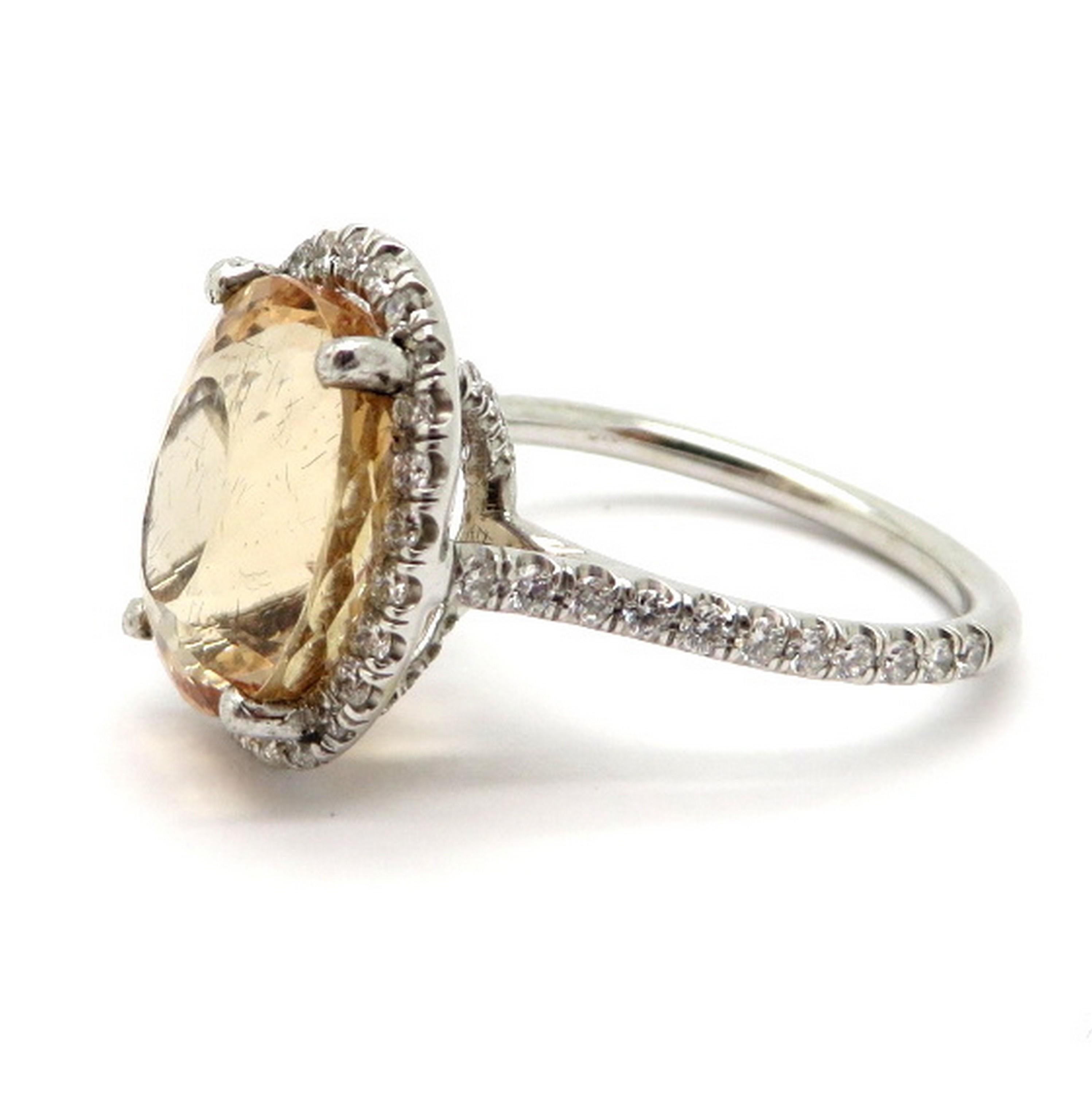 Estate 6.25 carat oval Imperial Topaz and diamond halo fashion ring. Showcasing one fine quality oval brilliant cut Imperial Topaz, four prong set, weighing approximately 6.25 carats. Accented with 71 round brilliant cut bead set diamonds, weighing