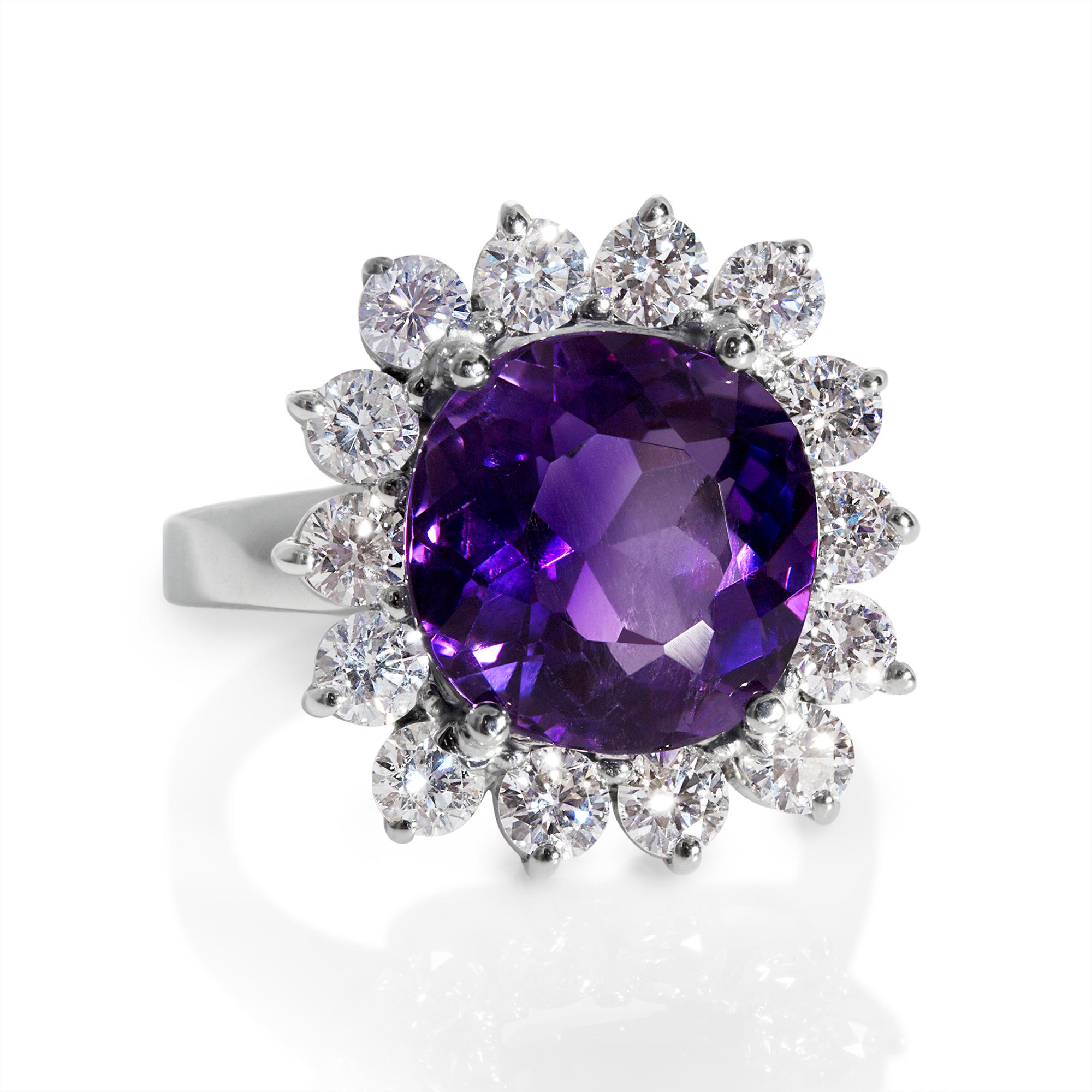 Make a sparkling statement with this impressive Mid-20th Century Amethyst and Diamond Dinner Cluster Ring. No keeping a low profile at the party, all eyes on you is guaranteed.
A gorgeous vivid deep violet-purple Antique old cushion-cut Amethyst,