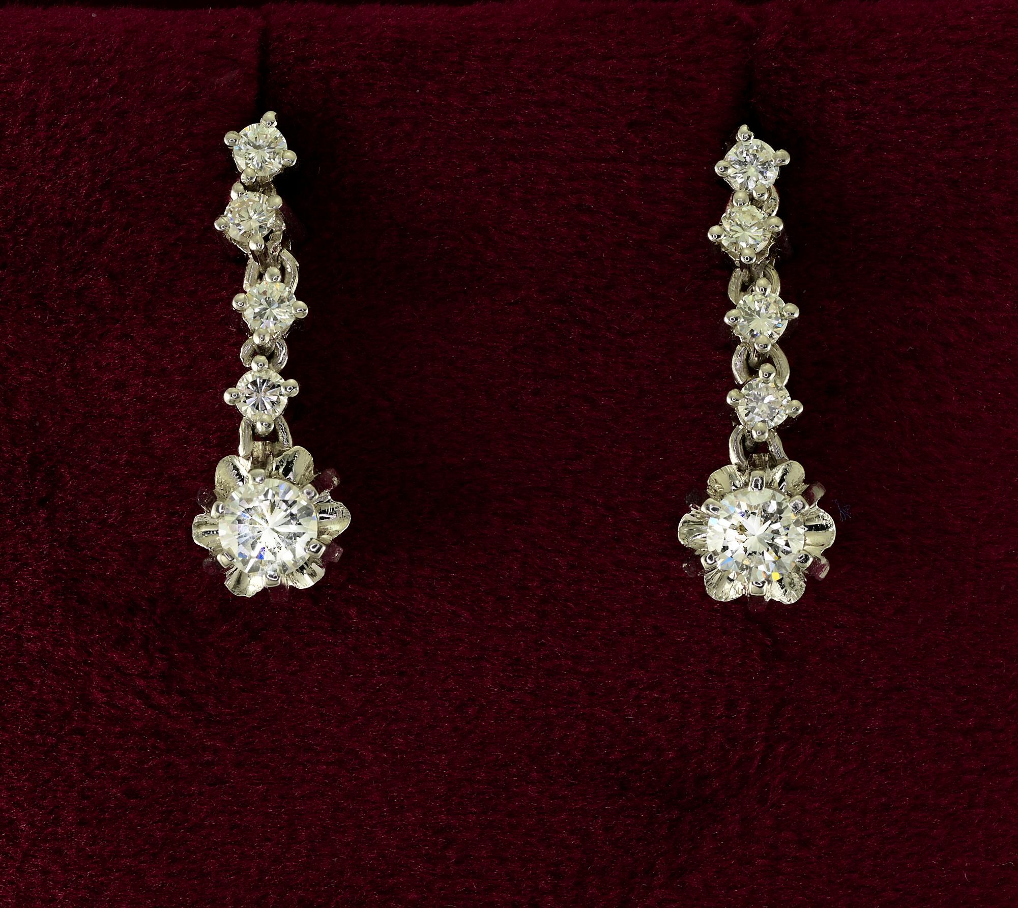 These lovely pair of Diamond drop earrings are 1950 ca
Classy timeless style hand crafted of solid 18 KT gold
Designed with a simple line of bright white Diamonds leading to the main Diamond which is larger in size and set in a flower head