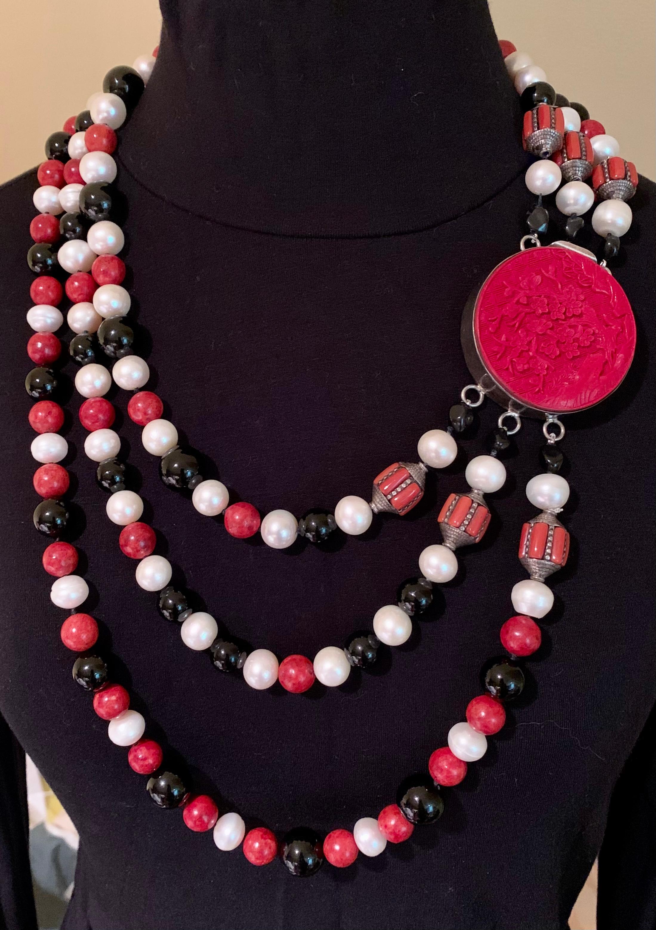 Striking, large triple strand Asian motif pearl, coral, onyx and sponge coral A. Jeschel Elaine Silverstein One-of-a-Kind statement necklace.
Provenance: from the estate of a noted New York City psychiatrist and collector of striking, unusual,