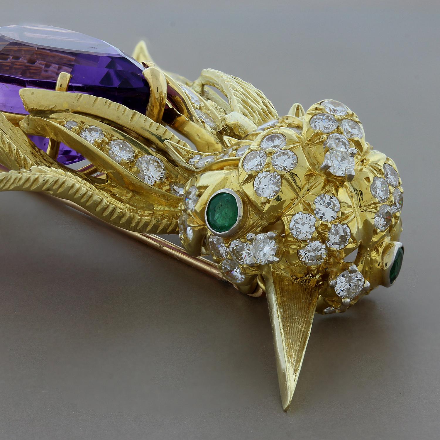 This soaring humming bird features a 17.90 carat pear shape purple amethyst.  4.07 carats of VS quality round cut diamonds are set throughout the 18K yellow gold brooch. The eyes are set with 0.15 carats of round cut emeralds. The feathers of this