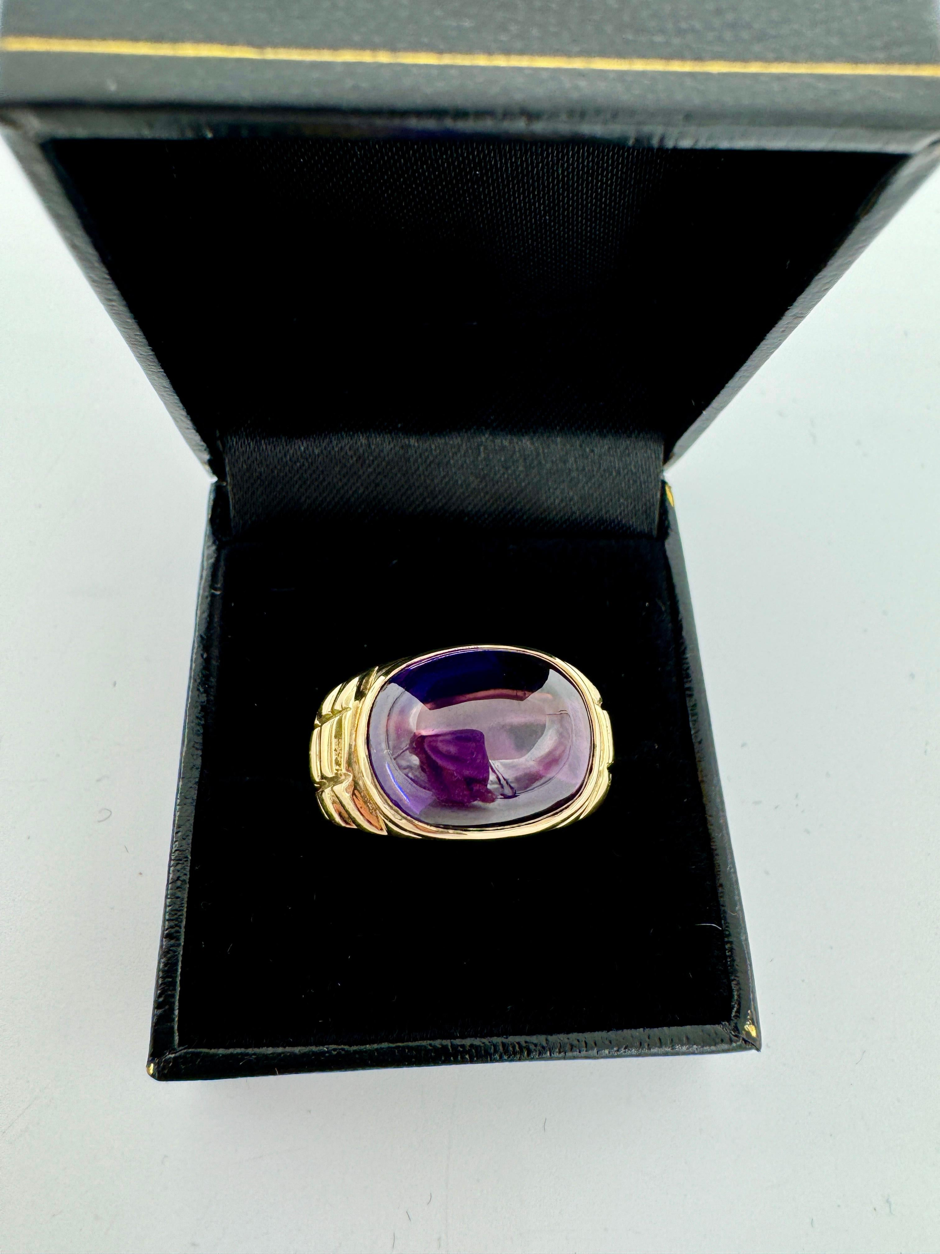 Estate cabochon Amethyst yellow gold ring, circa 1990s.

The Estate cabochon Amethyst yellow gold ring exudes elegance with its bold look.  The deep purple hue of the amethyst is complemented perfectly by the warm tones of the gold creating a
