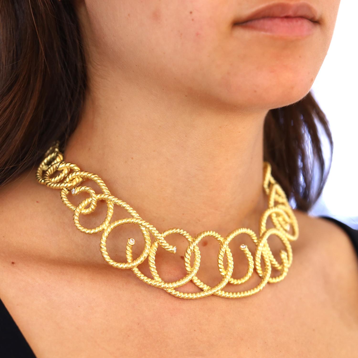 A bold, dramatic and fanciful 18k gold vintage collar necklace signed by noted designer Angela Cummings. Intriguing graduated concentric circles of twisted gold tipped with sparkling diamonds give way to seductive swirls at the neckline. The double