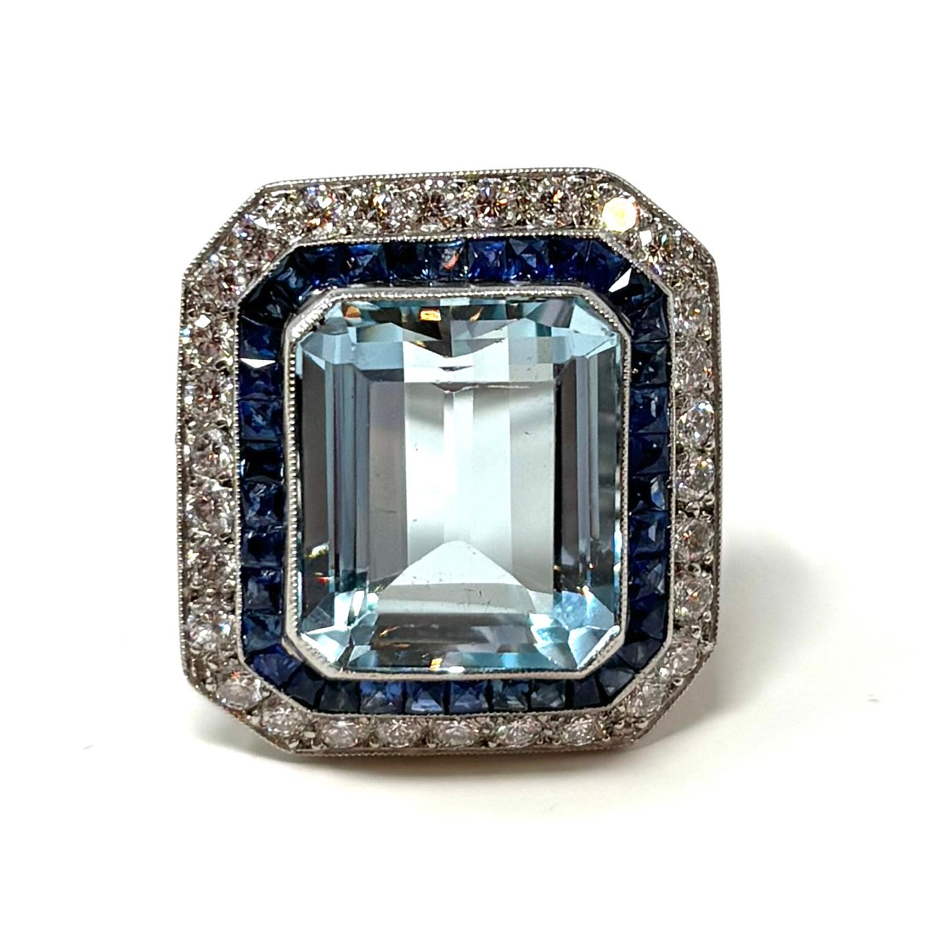 This is a striking Art Deco style cocktail ring that won't go unnoticed. The beautifully detailed platinum mounting contains a superb blue aquamarine weighing 
approximately 9.13 carats,  the diamonds are approximately .90 carats total weight, and