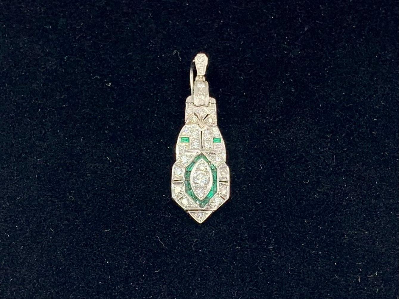 Interesting and distinctive estate Art Deco period platinum diamond and emerald pendant with a central design of a diamond eye framed by emeralds. The generous bale has an unusual feature of opening and closing which allows for wear on a wide ribbon
