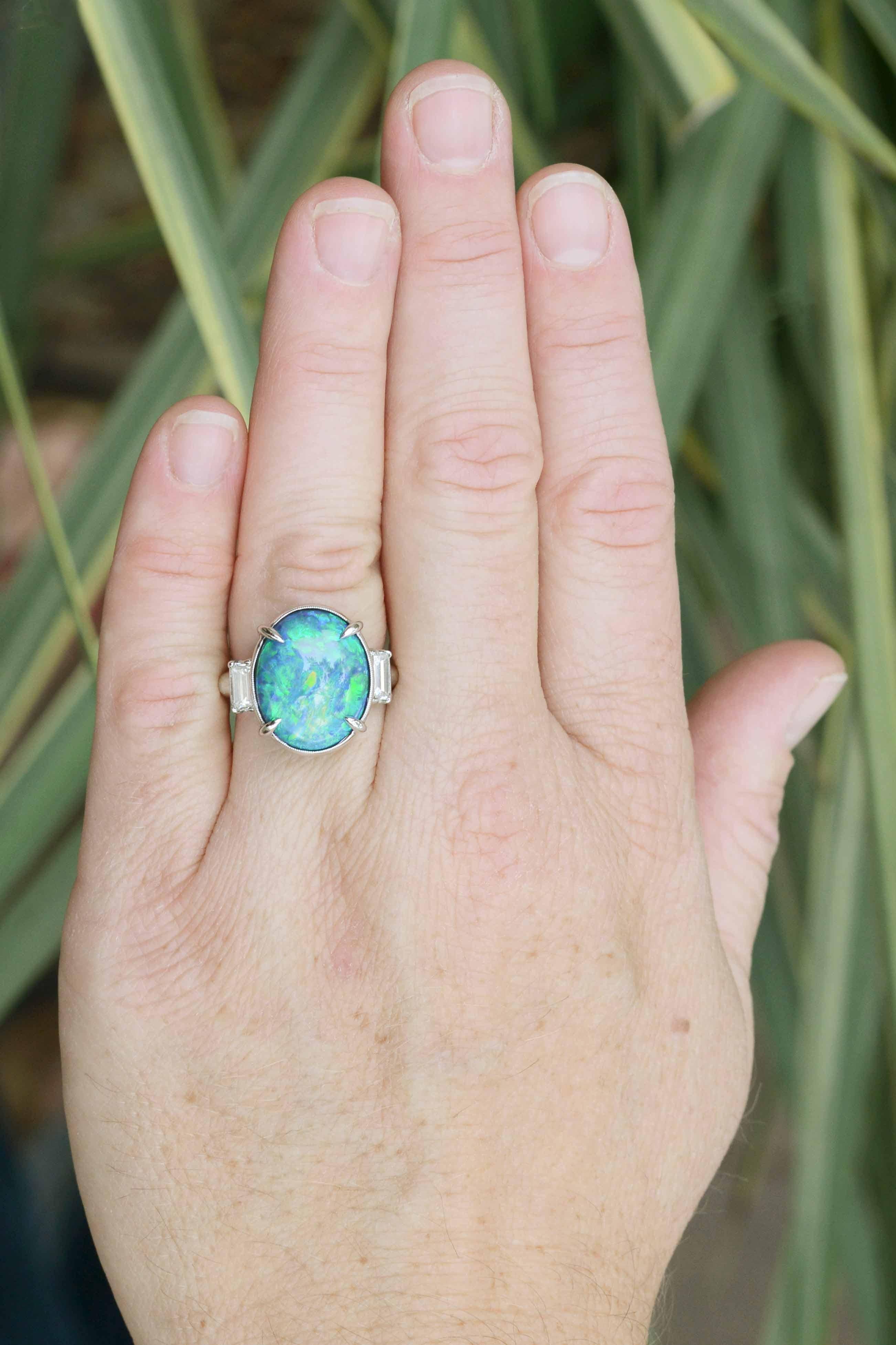 A vintage heirloom, this Art Deco black opal engagement ring is a most mesmerizing natural gemstone. Opals from Lightning Ridge, Australia are among the rarest and most beautiful gemstones. Centered by an over 9 carat oval with incredible rolling