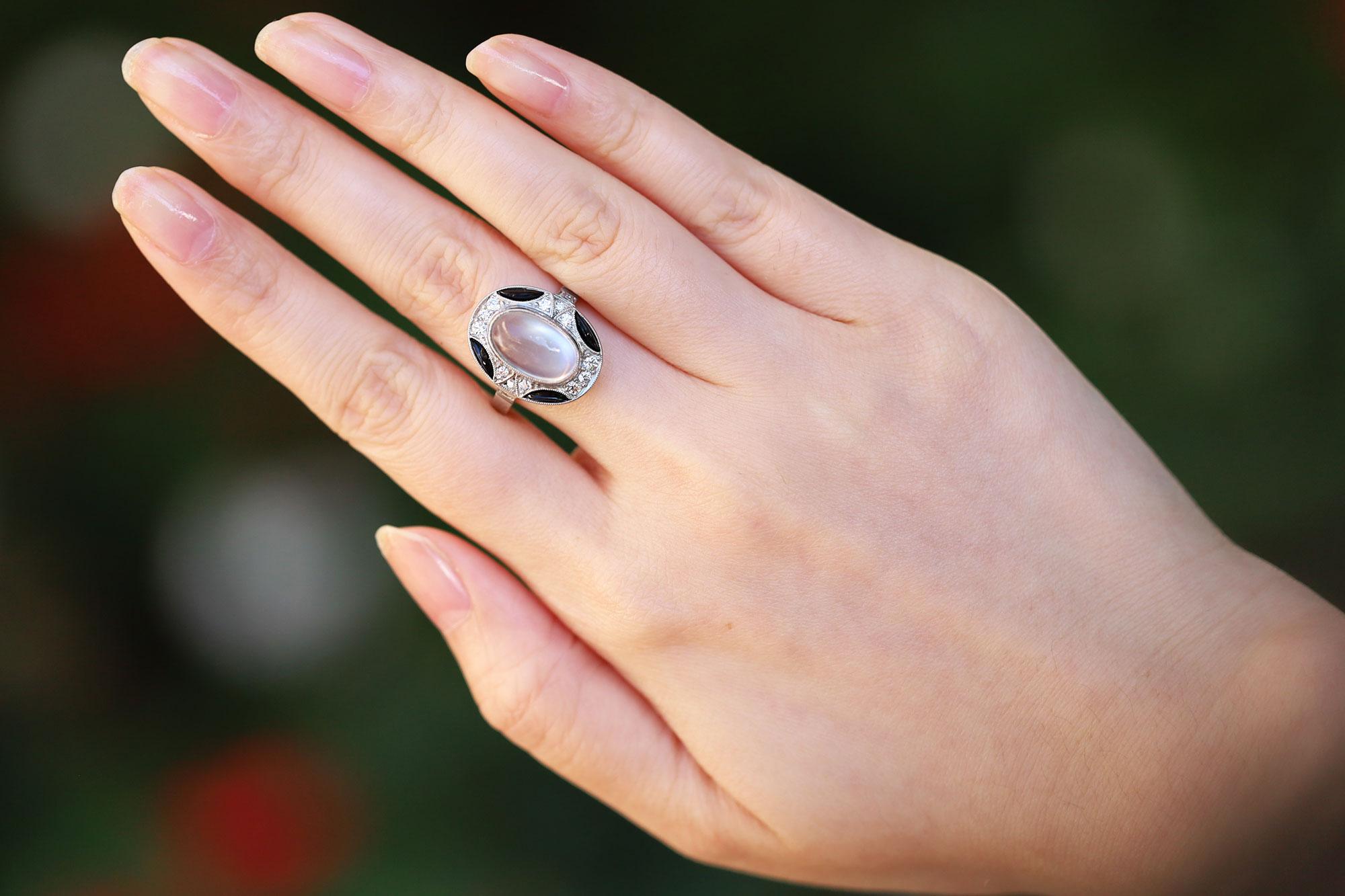 This unique vintage estate cocktail ring is crafted from platinum throughout and features a stunning 3.19 carat moonstone. The dreamy gemstone owns an ethereal, diaphanous sheen and is encircled with black onyx and 16 sparkling Old European