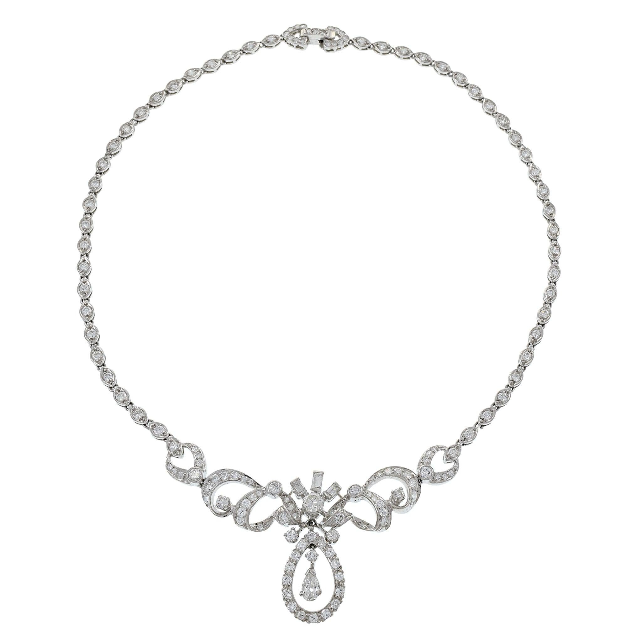 This exquisite estate necklace from the Art Nouveau era, weighing 31.93 grams, is crafted in platinum and features an elegant drop design. The necklace showcases a total of 6.00 carats of diamonds, including round and pear cut stones with G-J color