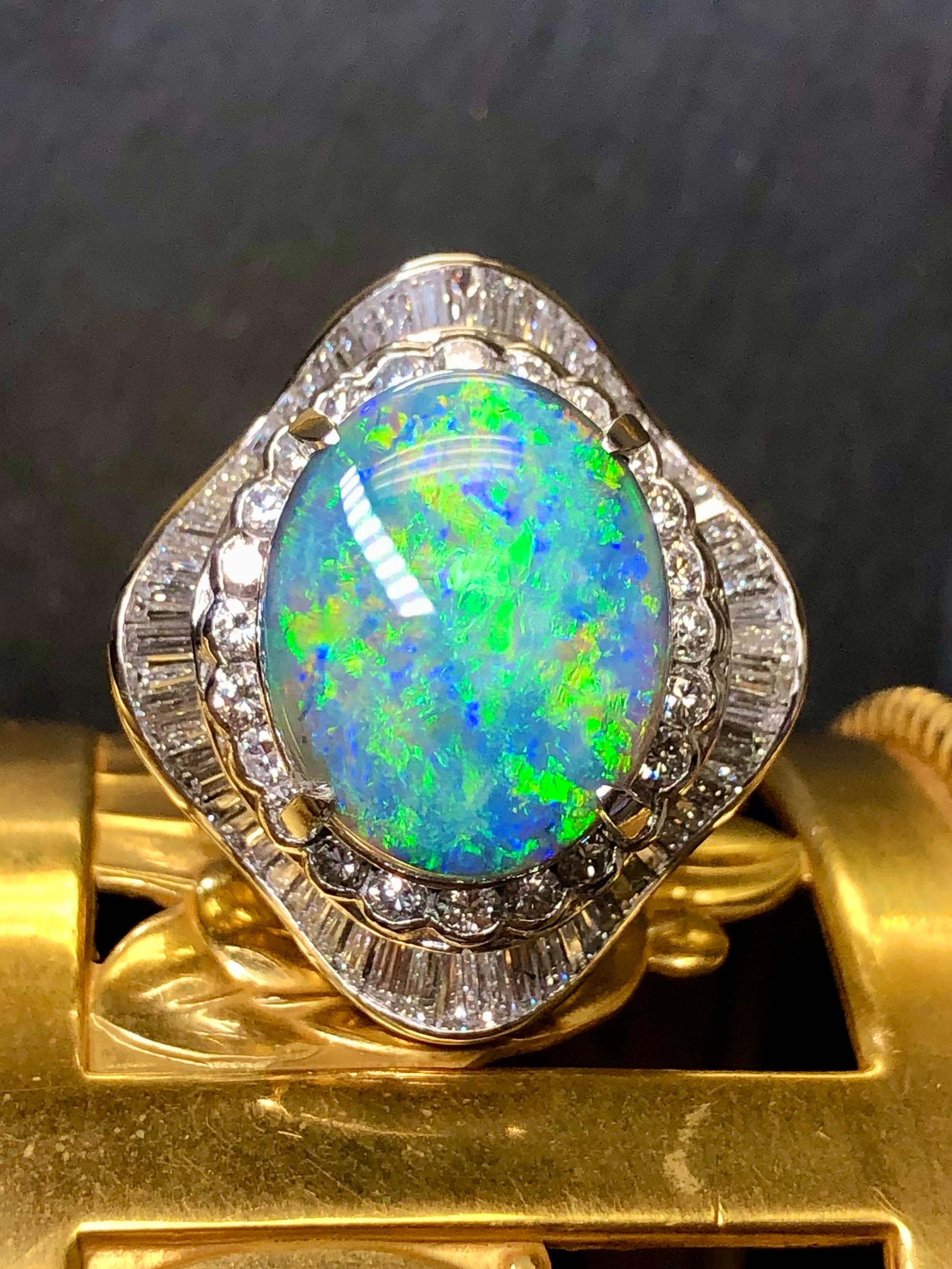 
Un anello spettacolare che sicuramente farà sciogliere il tuo cuore. Realizzato in platino pesante, questo grande anello da cocktail è centrato da un opale nero cabochon di circa 9ct che mostra splendidi lampi di verde, blu e giallo, con piccole
