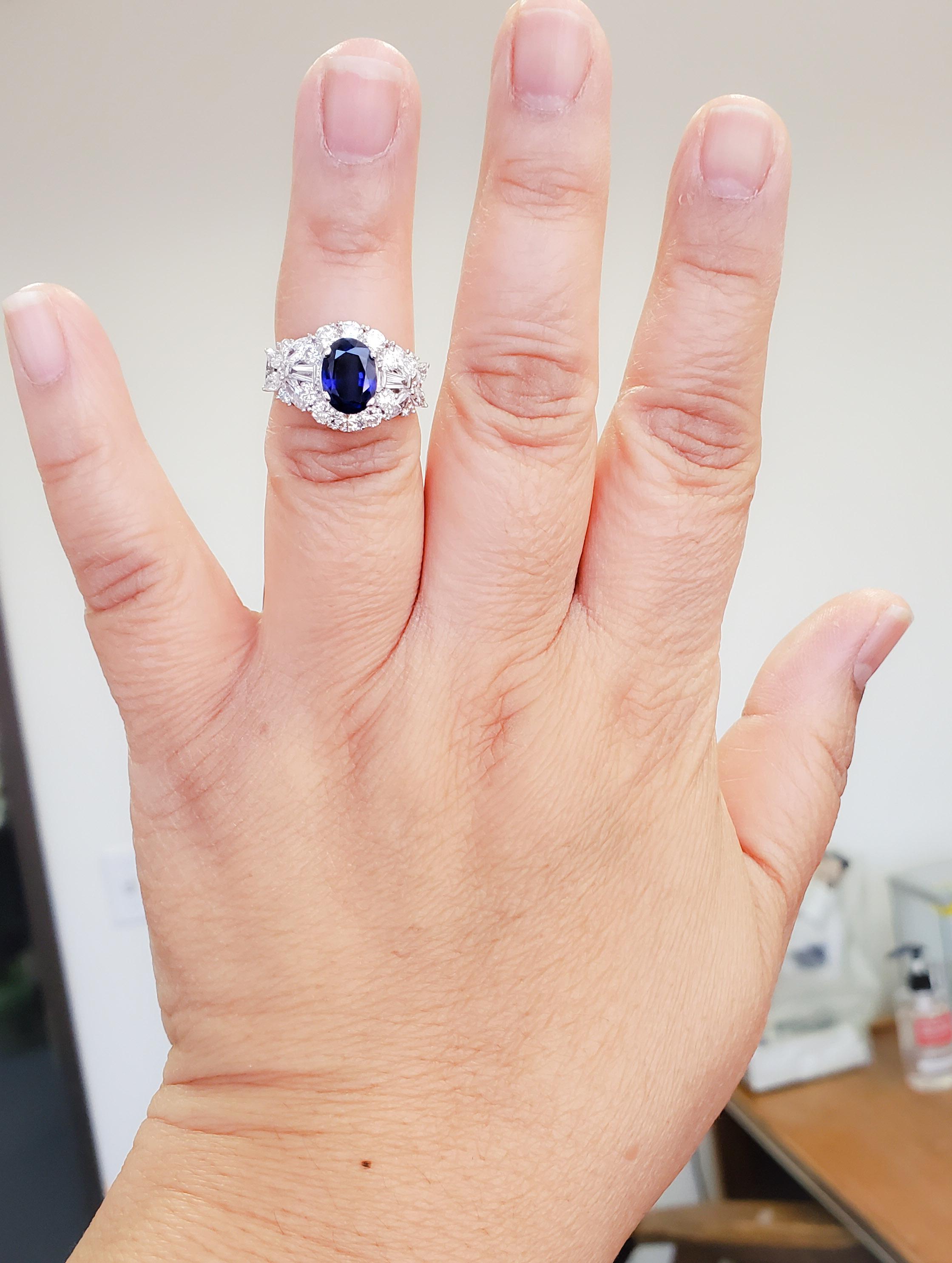 Beautiful 1.96 ct. bright blue sapphire oval with 2.25 ct. good quality white diamond rounds, marquises, and baguettes.  Handmade 18k white gold mounting in ring size 6.