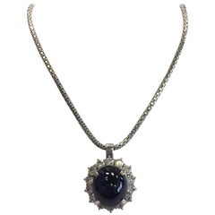 Collana con zaffiro blu ovale cabochon e diamanti in oro bianco 18 carati