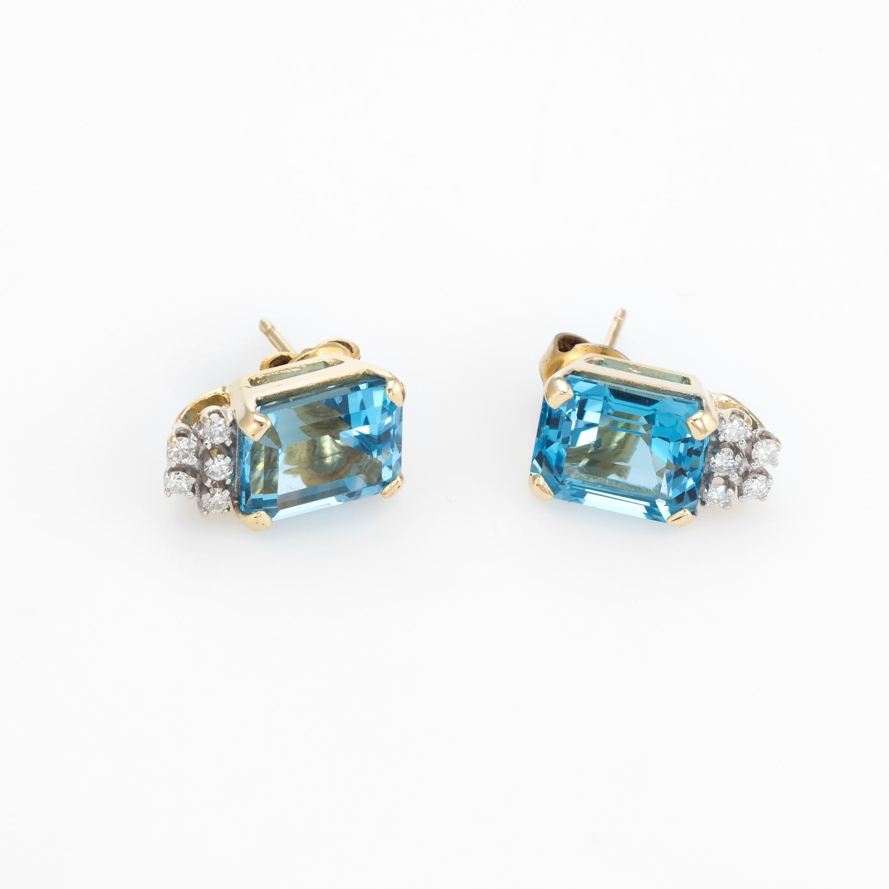 Elegant pair of estate blue topaz & diamond stud earrings, crafted in 14k yellow gold. 

Emerald cut blue topaz measures 10mm x 8mm (estimated at 4.50 carats each - 9 carats total estimated weight), accented with 10 estimated 0.01 carat round