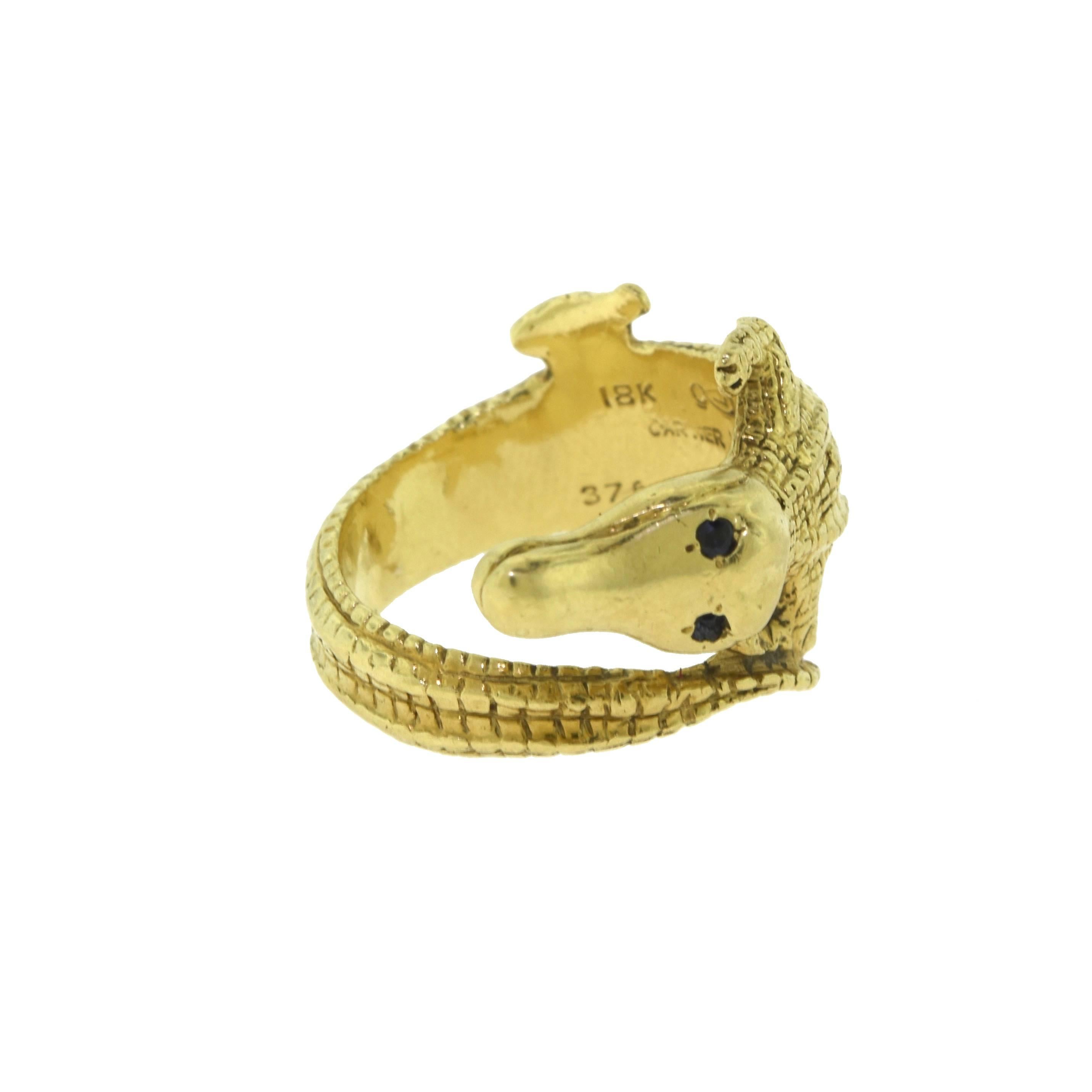 Designer: Cartier
Metal: Yellow Gold
Metal Purity: 18k
Stones: 2 Small Sapphire Eyes 
Total Item Weight (g): 12.4
Ring Size: 5
Ring Width: 14.91 mm tapers to 4.87 mm
Signature: Cartier