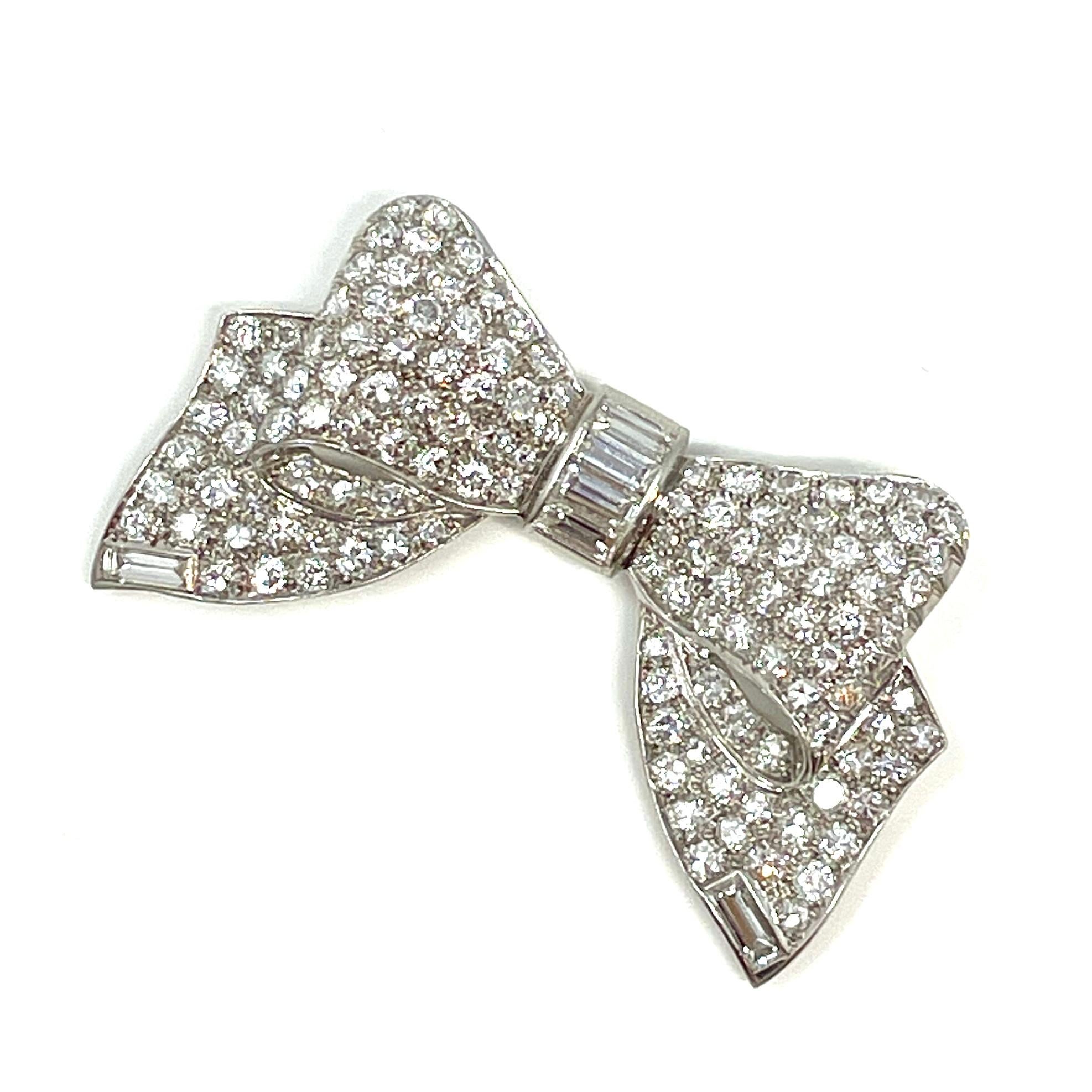 Classic Estate 1940's-1950s platinum bow brooch signed by Cartier, containing approximately 7 carats total weight of round brilliant and baguette cut diamonds.