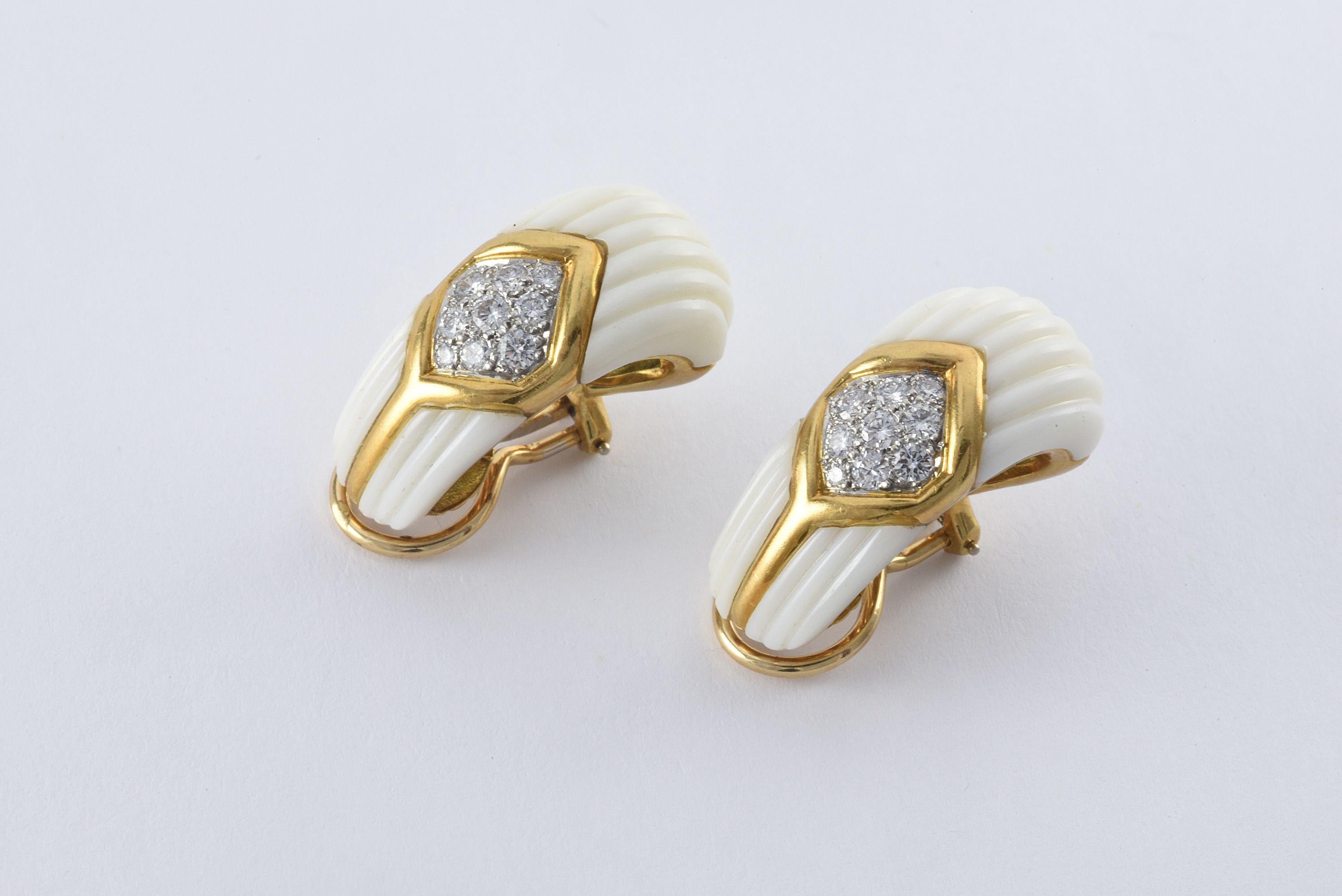 Fashioned in 18kt yellow gold, these beautiful estate ear clips feature carved white coral and eighteen round diamonds totaling approximately 1.00 carat, EF color, VS clarity.  
