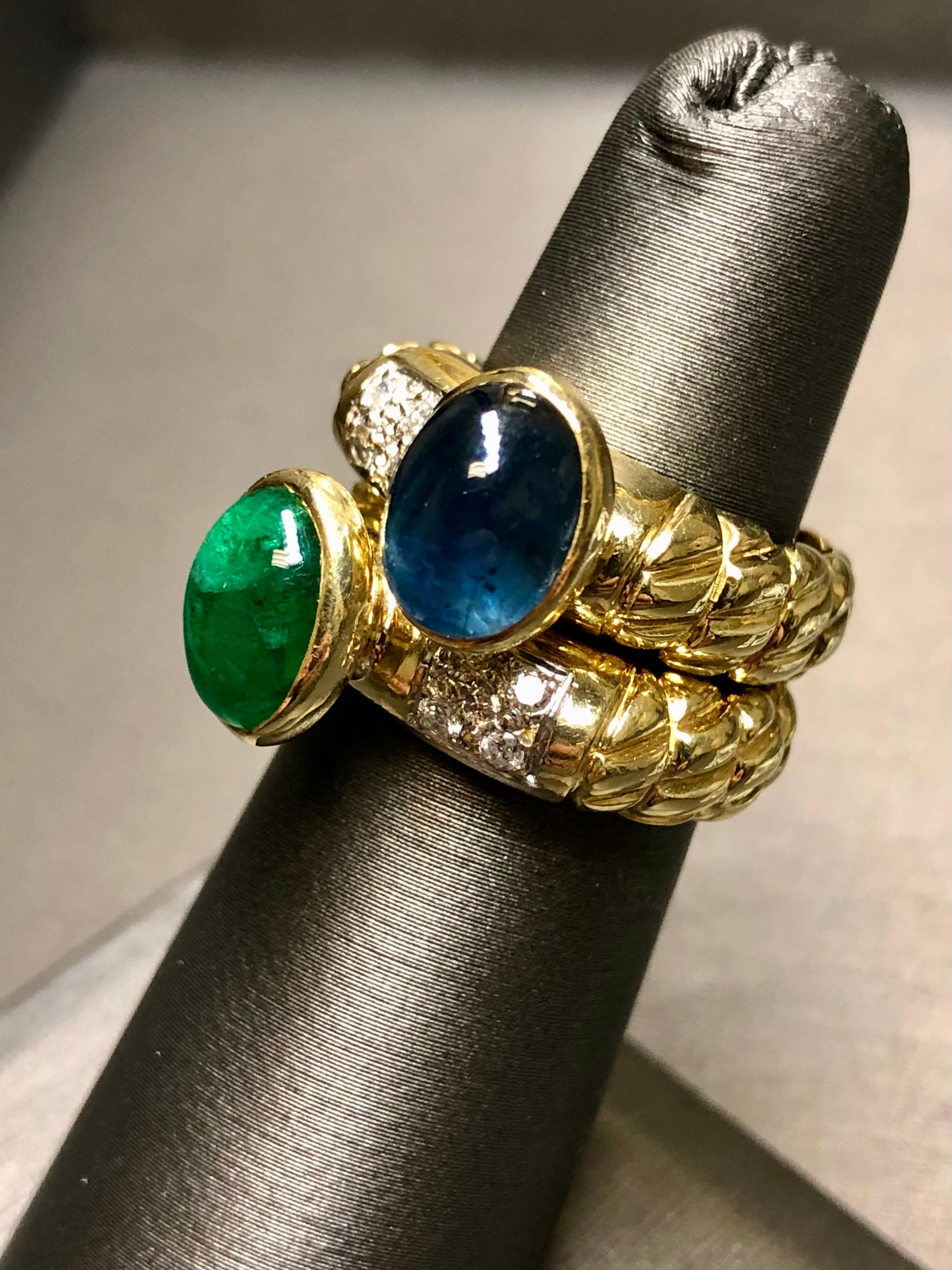 A gorgeous double ring set done in 18K yellow gold with one ring centered by an approximately 2.50ct cabochon emerald and the other a 3.60ct cabochon sapphire. Between both rings there is another approximately .16cttw in H-J color Si1-2 clarity