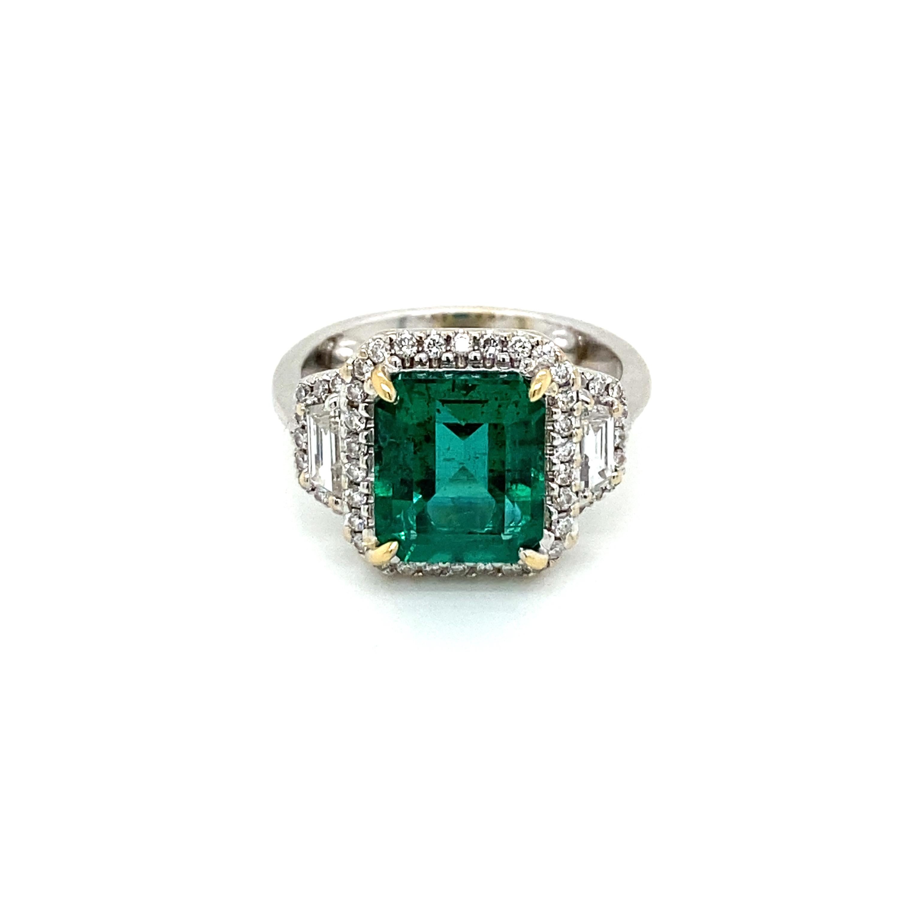 An exquisite ring set in 18k white gold, featuring a Rare vivid 3,34 ct. Emerald-cut Zambian Emerald, surrounded by 2 carats of Sparkling Round and Baguette shape diamonds, graded G color Vvs1 clarity.

The Emerald color is graded Intense bluish