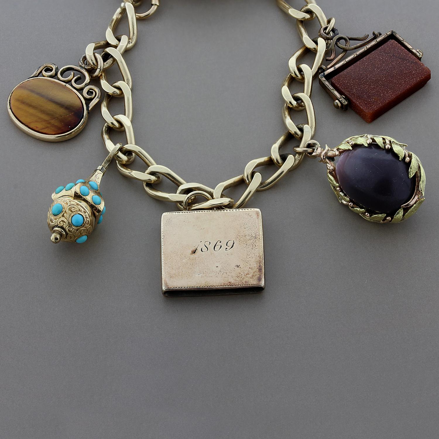 Charmed! This estate charm bracelet has a lot going on. It features a purple egg, a gold tassel and unique gemstones such as carved tigers’ eye, turquoise, sunstone and the lovely pearl with gorgeous black enamel filigree. Made in 14K yellow