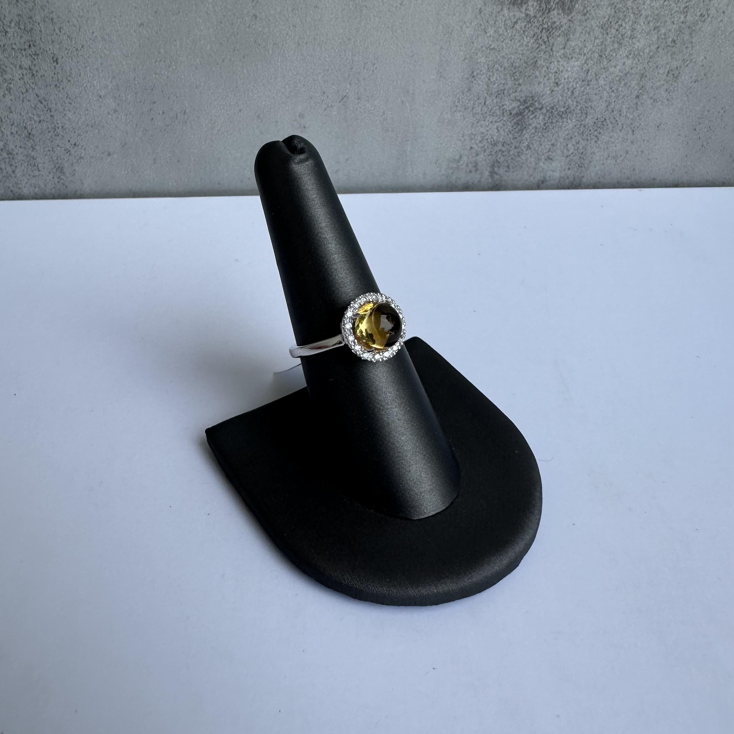 Enhance your jewelry collection with this exquisite Estate Citrine and Diamond Ring in 14kt White Gold. Featuring an 8.1mm cabochon citrine and 0.24 carats of GH SI natural round diamonds, this ring combines timeless beauty with modern elegance,