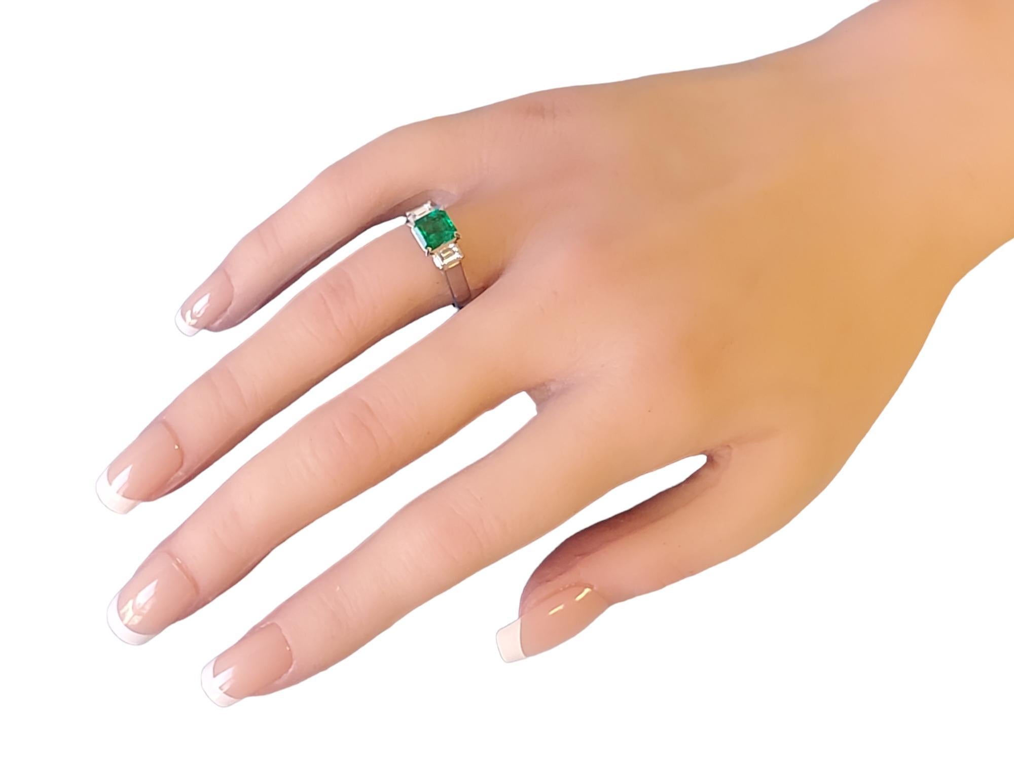 Estate platinum ring with a 1.13ct Colombian Emerald step cut stone flanked with 2 white Vs diamond baguettes .35tcw. The emerald features a deep and vibrant green color indicative of Colombian emeralds. This ring is accompanied with a GIA report.