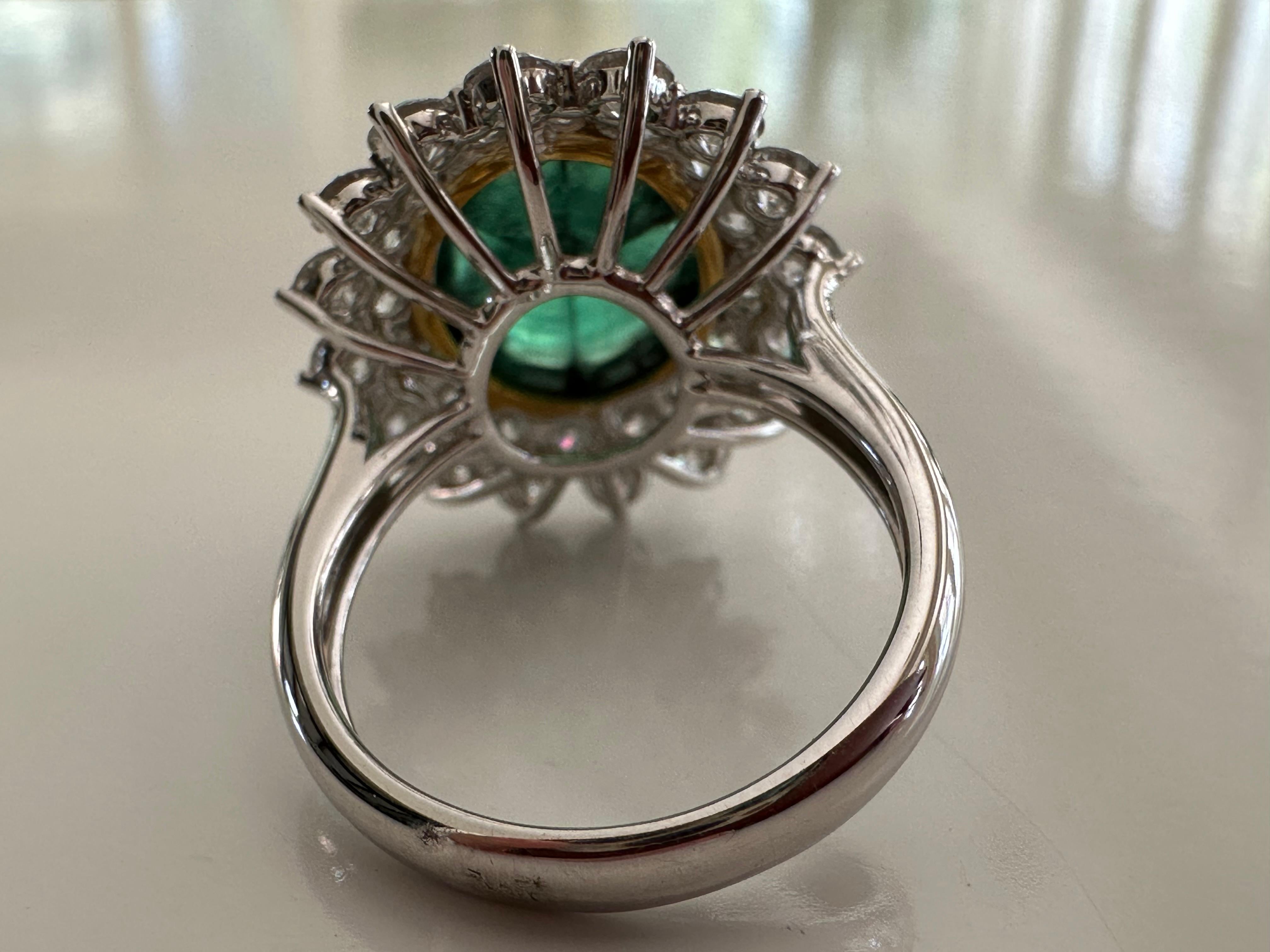 This exquisite ring features a rare 5.21-carat natural Colombian trapiche emerald oval-shaped cabochon   framed by 2.57 carats of round brilliant-cut diamonds.  The stone's trademark wheel spoke pattern is the result of black carbon impurities that
