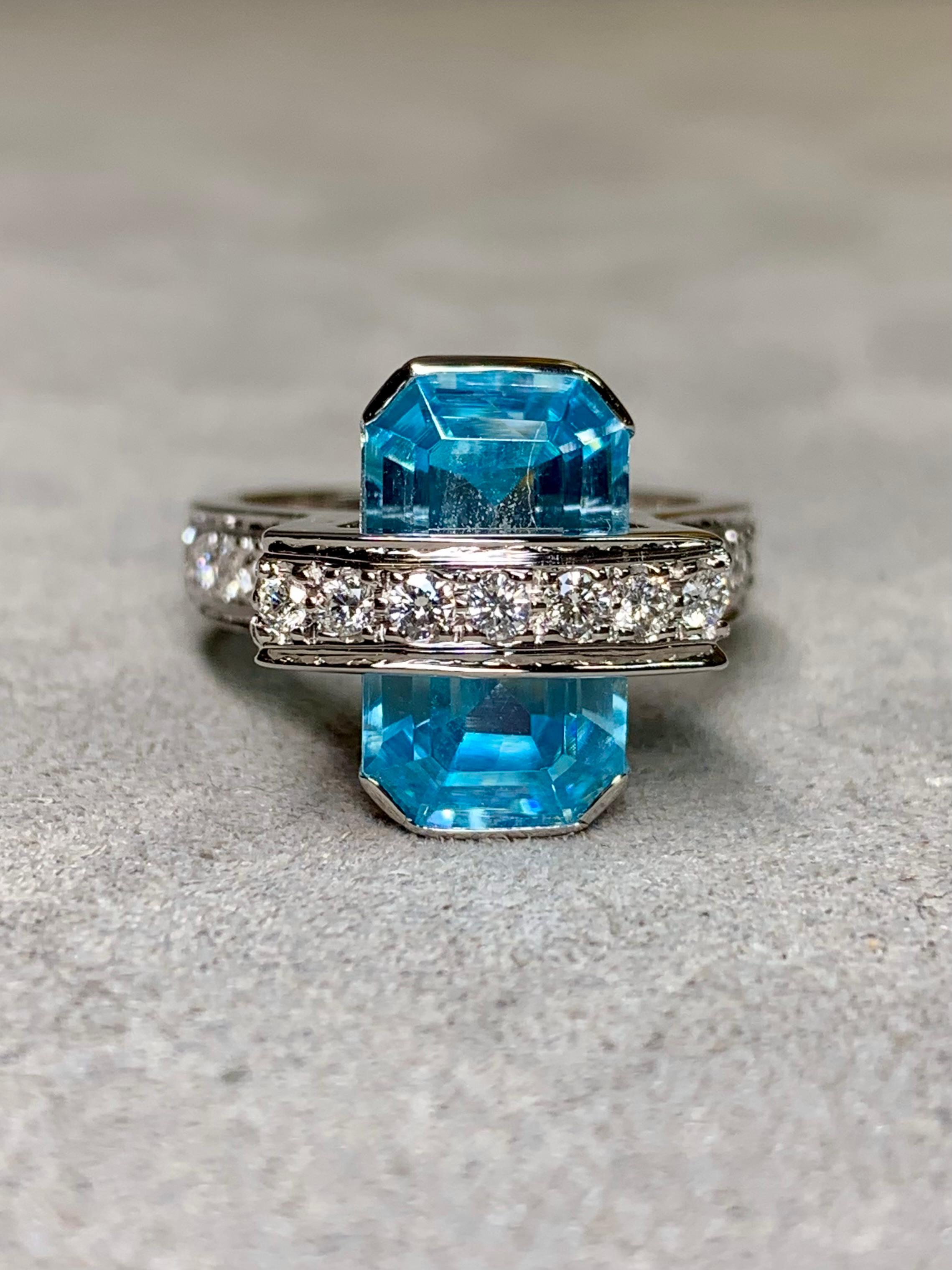 
Un anillo de herencia llamativo y contemporáneo, maravillosamente hecho a mano en sólido y pesado oro blanco de 18 quilates. En su centro descansa una aguamarina natural talla esmeralda de 3,68 quilates de color azul brillante, cuya nítida