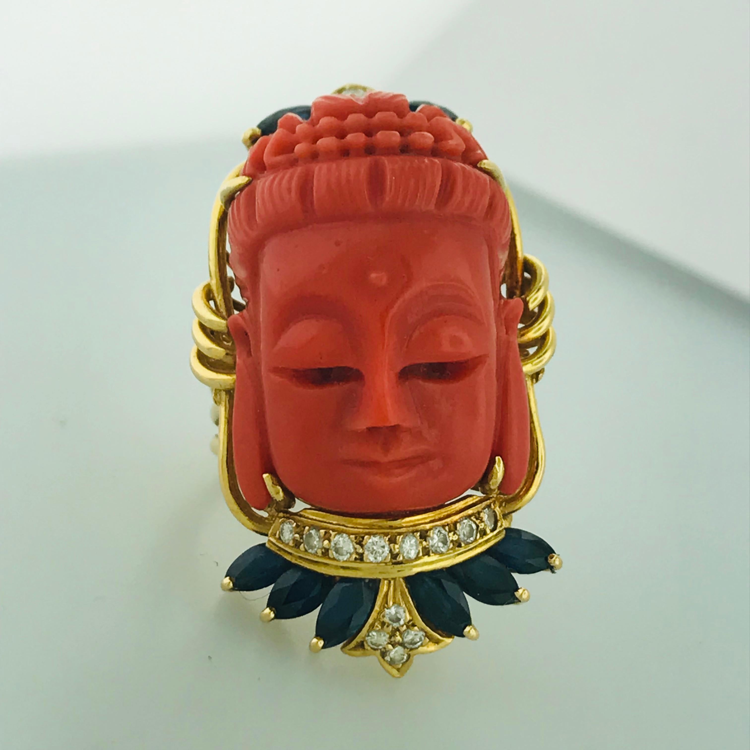 This estate buddha ring is one of a kind and very special! With a genuine carved coral piece and deep blue sapphire gemstones, accented with natural white diamonds. The rich 18kt yellow gold contrasts beautifully with the natural gemstone colors.