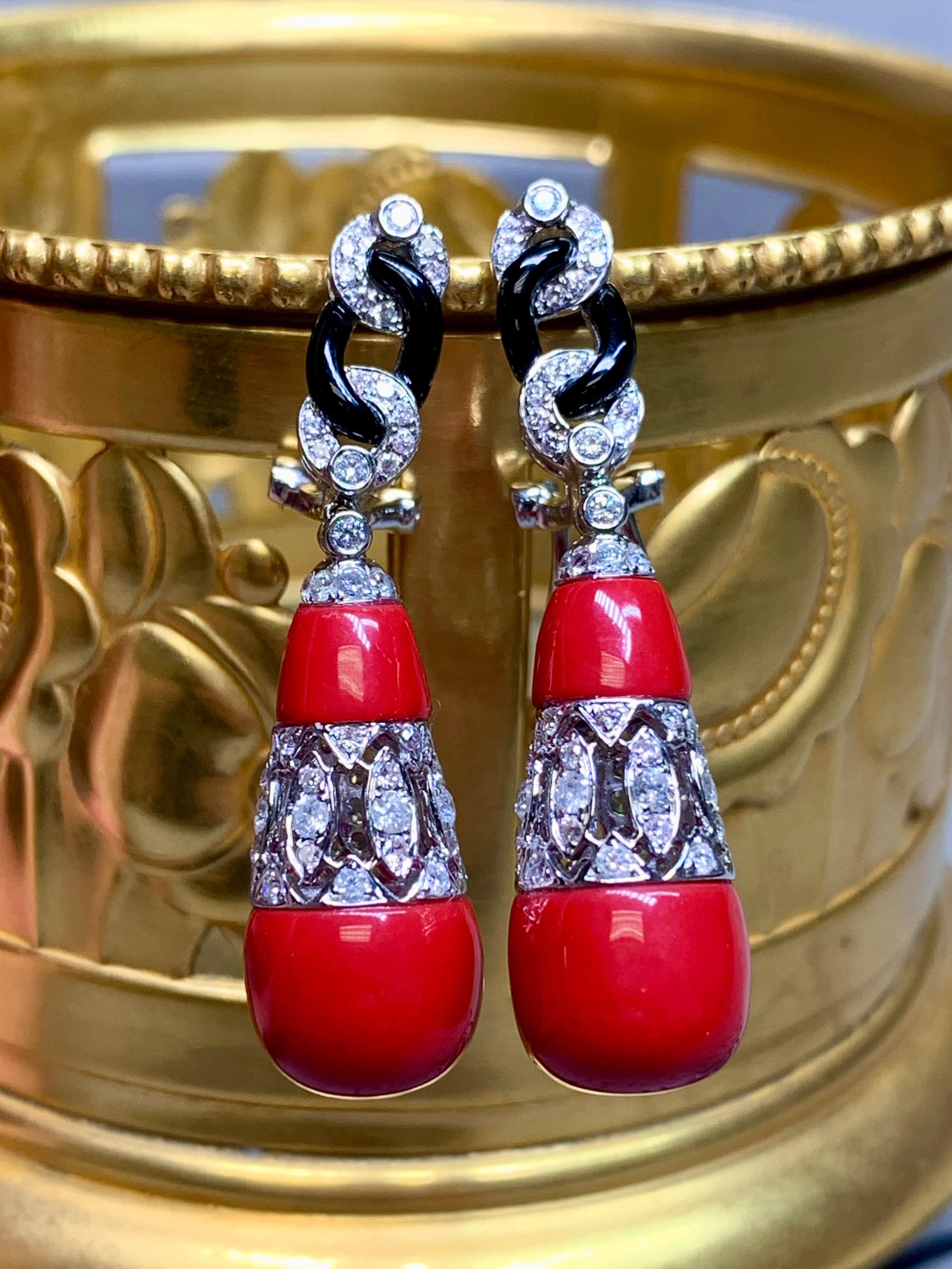 These estate earrings, newly created in the Art Deco style, capture the drama and elegance of the Jazz Age. Crafted in luminous 18K white gold, each design showcases a vivid red coral drop, crowned with diamond accents that sparkle with light at