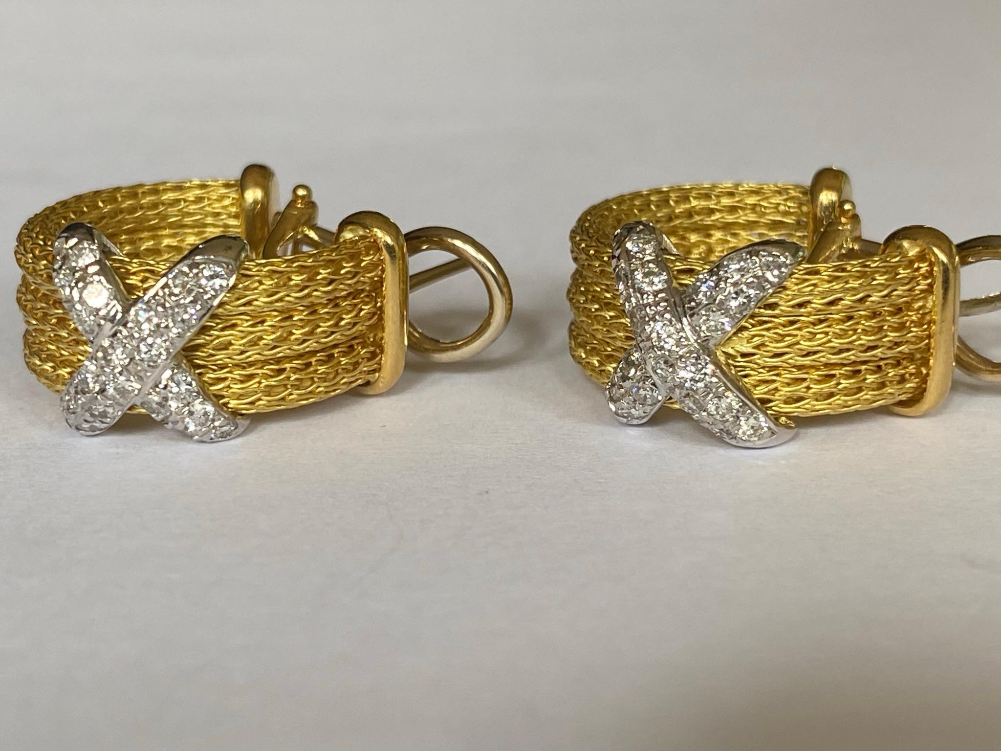 These two-tone Estate earrings feature three rows of 18kt yellow twisted gold rope overlaid by a crisscross of twenty-two round diamonds set in 18kt white gold and secured with Omega backs. The total diamond weight is approximately 1.00 carat. 

