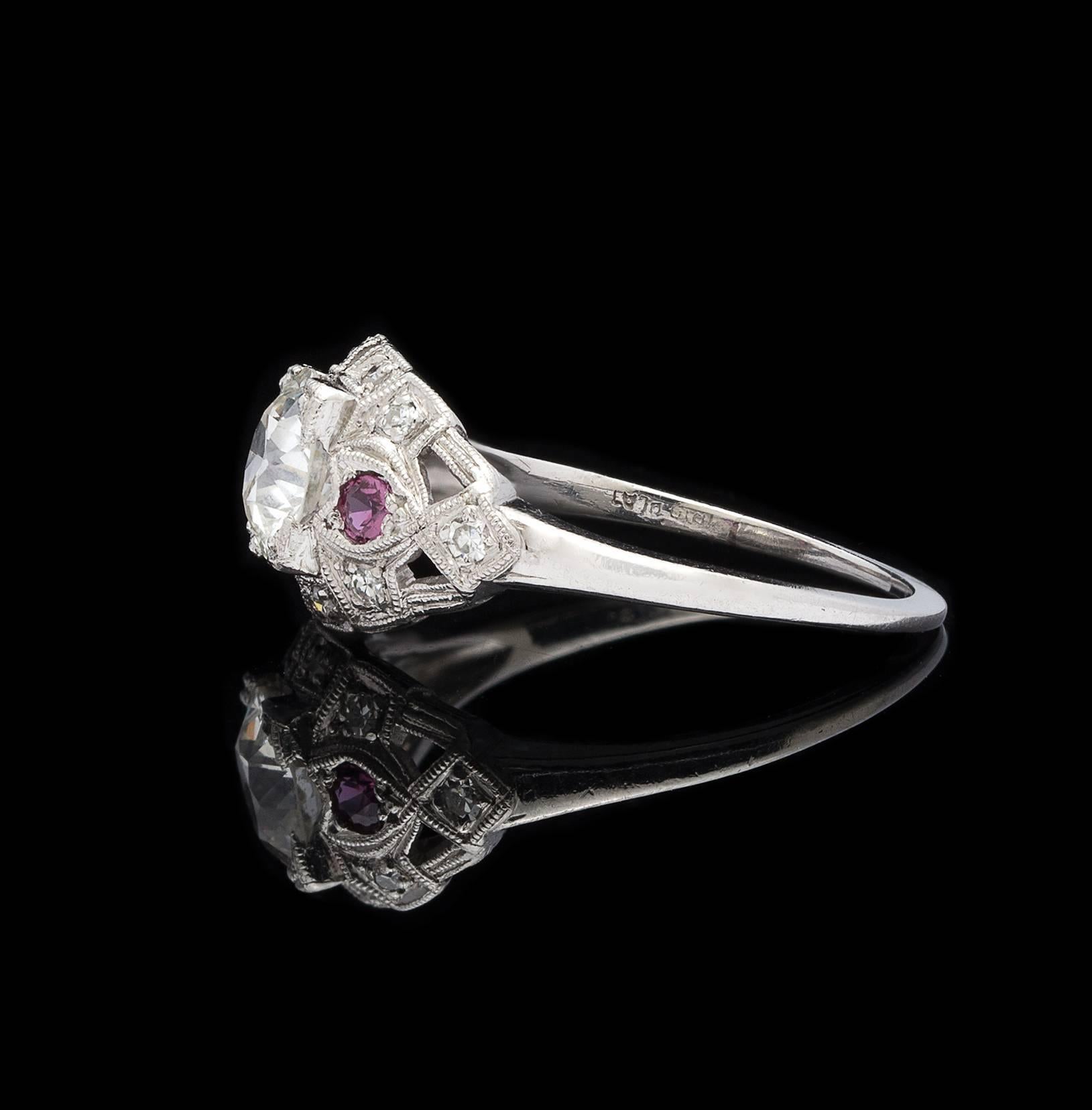A charming ring featuring an old European-cut diamond weighing 0.82 carat, graded G-H color and VS-SI clarity, the slightly domed platinum mounting highlighted with two round-cut rubies and 11 single-cut diamonds. Estimated total diamond weight for