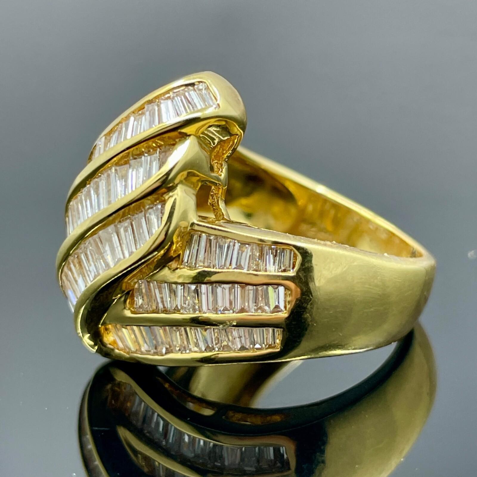 Bague de cocktail en or jaune 18 carats avec 101 diamants baguettes

Cette pièce d'apparat de style vintage a été réalisée en or jaune 18 carats et sertie de 101 diamants baguettes en serti clos pesant 2,60ctw. Cette bague de cocktail accrocheuse