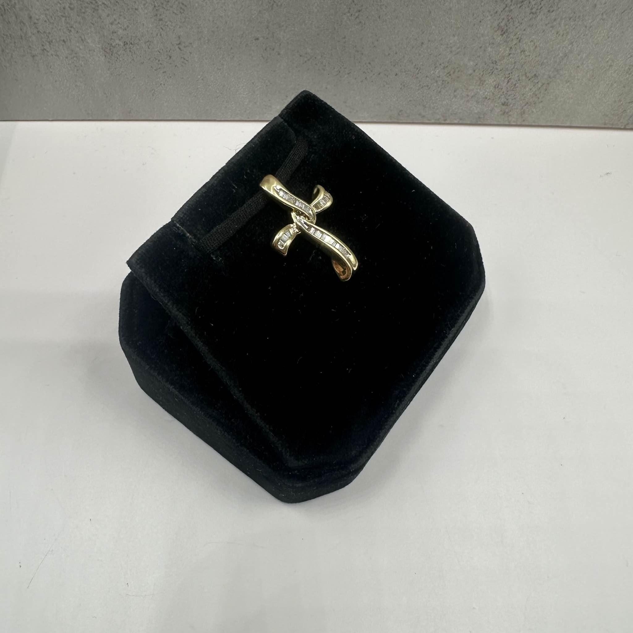 Cette superbe croix en or jaune 14kt est ornée de 0,25ctw de diamants baguettes GH SI naturels, offrant un éclat raffiné et une élégance intemporelle. Avec un poids de 2,3 grammes, cette pièce est substantielle mais confortable à porter au