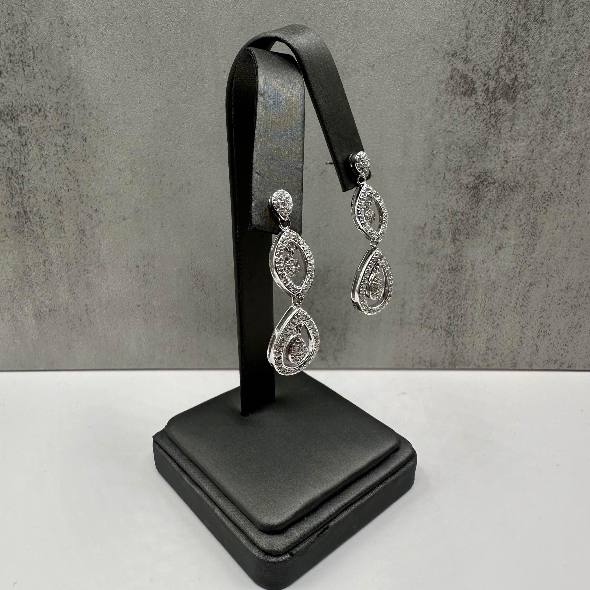 These stunning Estate Diamond Drop Earrings in 14kt white gold feature approximately 0.7ctw of natural GH SI-I1 eye-clean round single-cut diamonds, providing beautiful sparkle. With a height of approximately 1.5 inches, these earrings make an