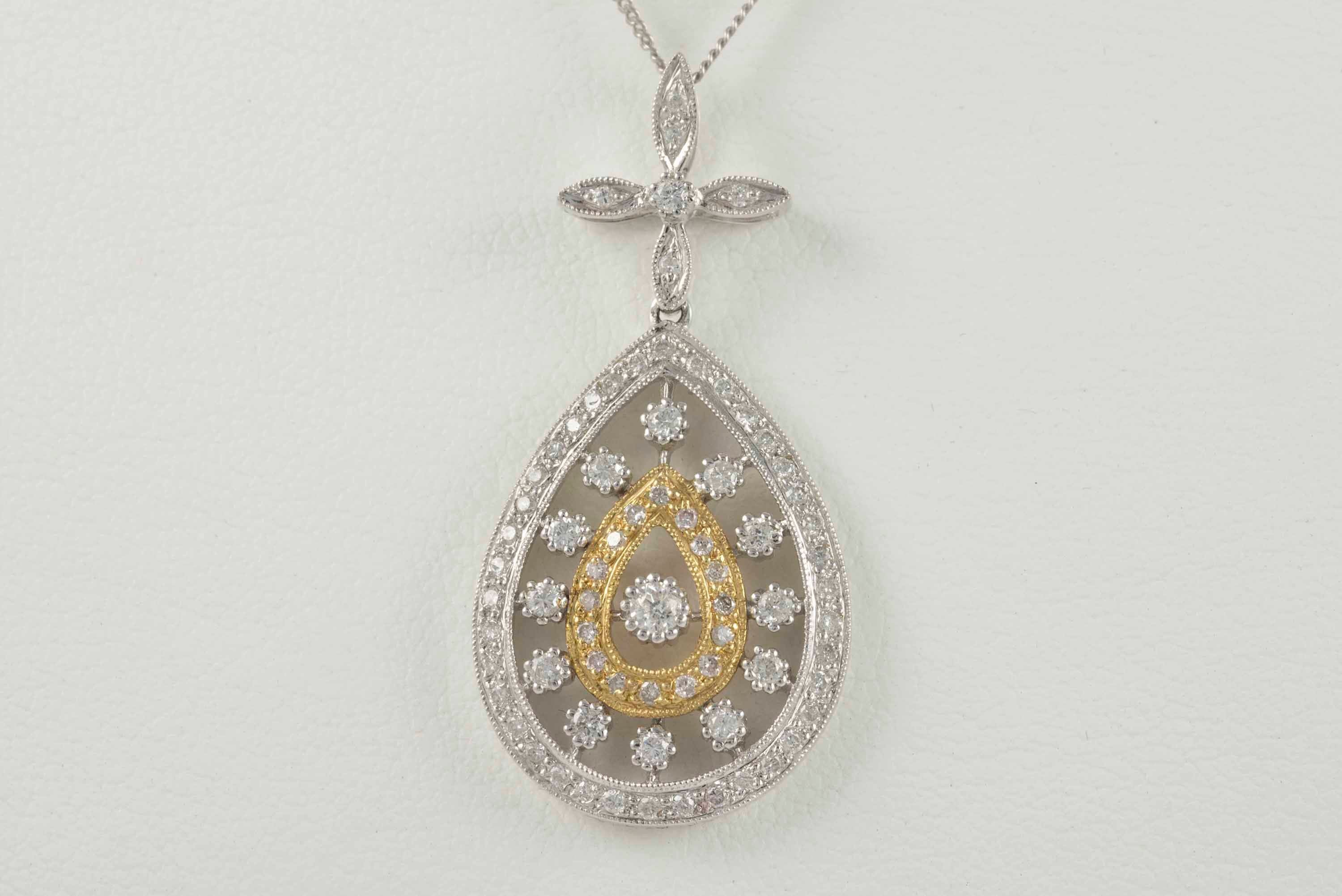 Crafted in 14kt white and yellow gold, this estate necklace features a flower and tear drop pendant adorned with seventy-three round diamonds, H-I color, SI-I1 clarity, totaling approximately 0.70 carats. The chain is 18 inches long. 

