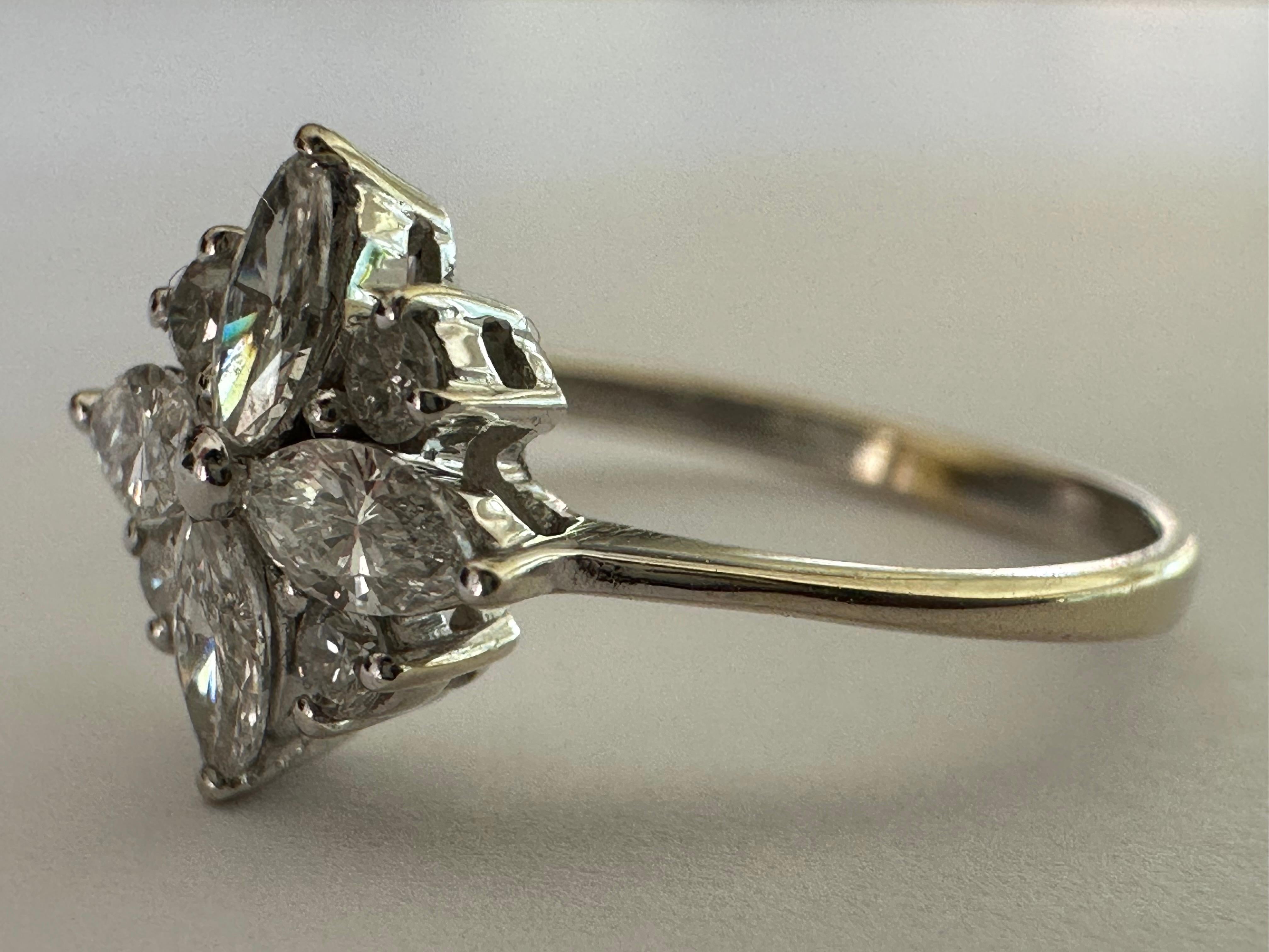 This stunning ring forms an elegant eight-petal flower bejeweled with four marquise diamonds and four round brilliant-cut diamonds totaling 0.27 carat, GH color SI clarity. Set in 14K white gold. 
