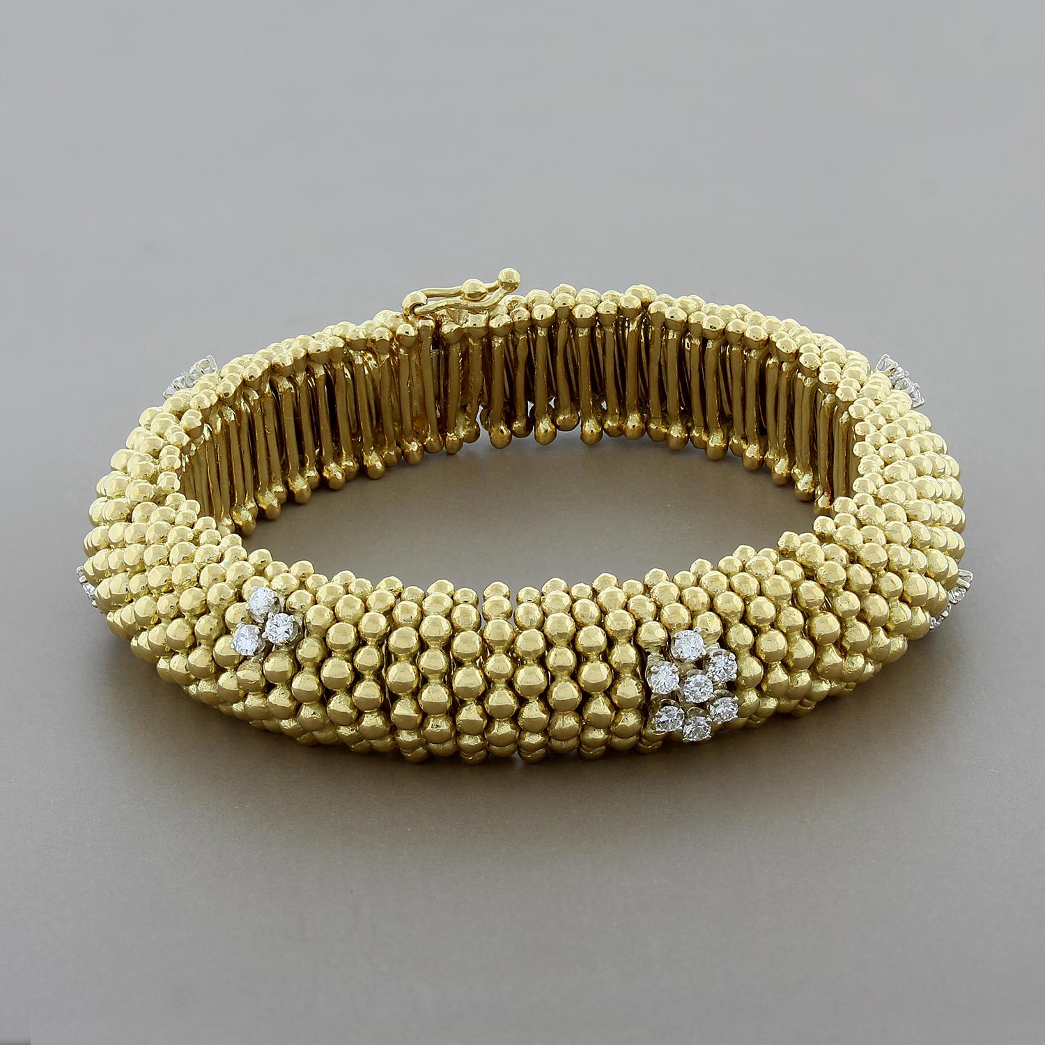 This estate bracelet features 0.64 carats of round cut diamonds throughout. The diamonds create clusters over the gold bead design with one flower cluster in the center. This bracelet has been masterfully crafted with detail even on the inside - it